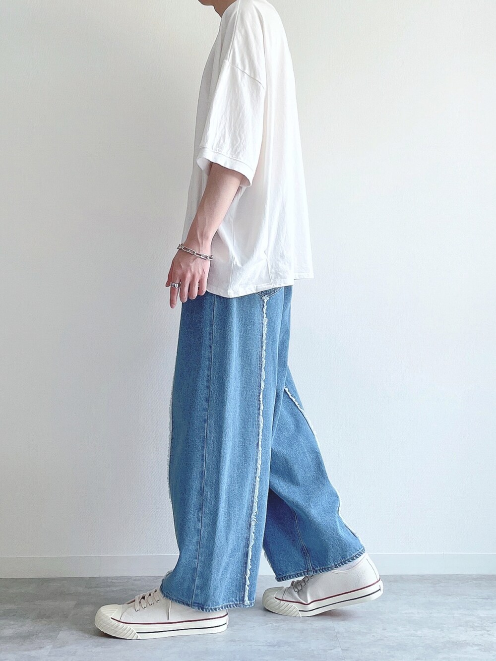 ホワイト系のTシャツ/カットソー、ブルー系のデニムパンツ、ホワイト系のスニーカーを着用したメンズの春コーディネートの3枚目の写真