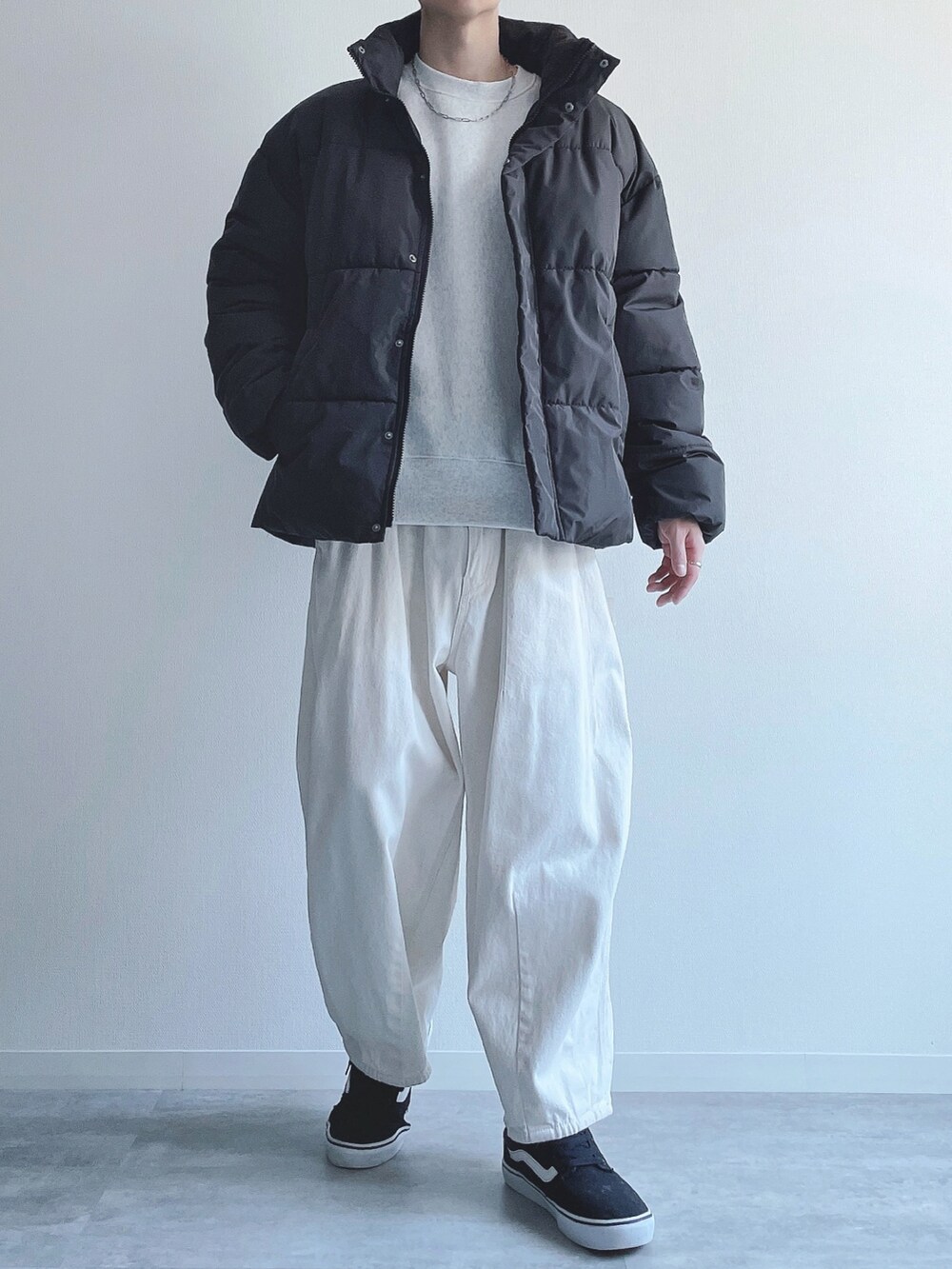 ブラック系のダウンジャケット/コート、グレー系のトップス、ベージュ系のパンツを着用したメンズの冬コーディネートの4枚目の写真