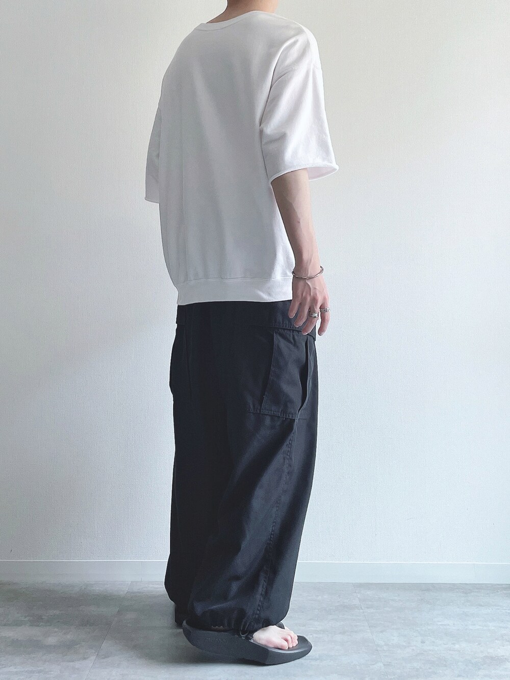 ホワイト系のTシャツ/カットソー、ブラック系のその他パンツ、ブラック系のサンダルを着用したメンズの夏コーディネートの3枚目の写真
