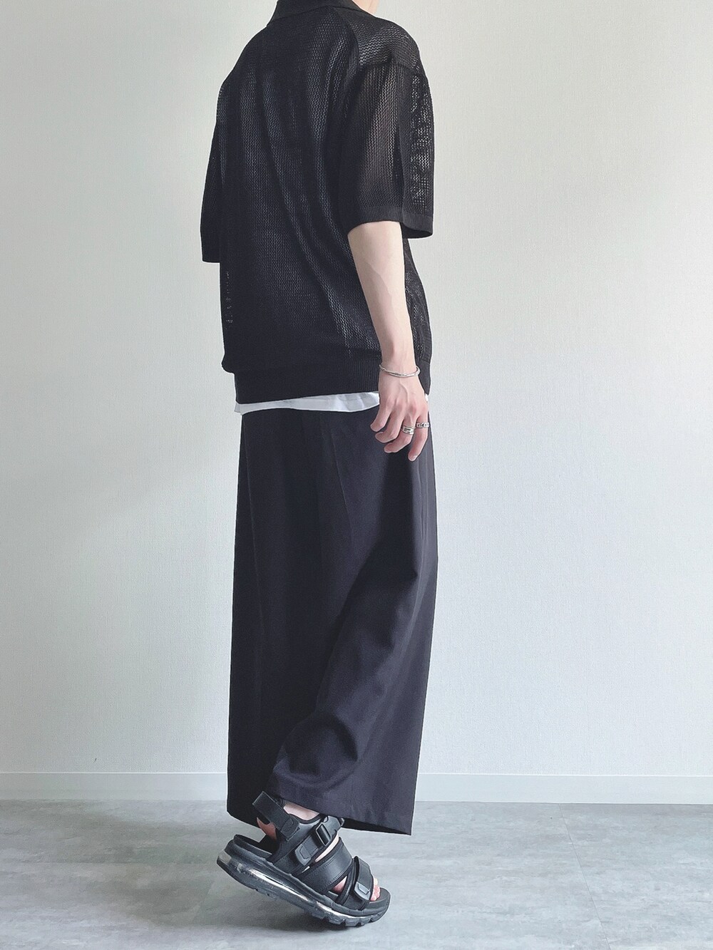 ブラック系のトップス、ホワイト系のタンクトップ、ブラック系のスラックスを着用したメンズの夏コーディネートの4枚目の写真