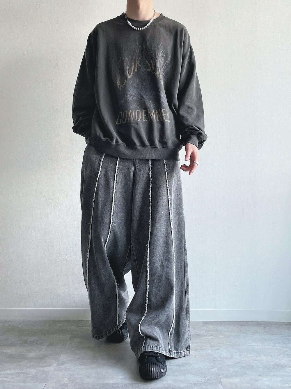 グレー系のスウェット、グレー系のデニムパンツ、ブラック系のスニーカーを着用したメンズの春コーディネートの2枚目の写真