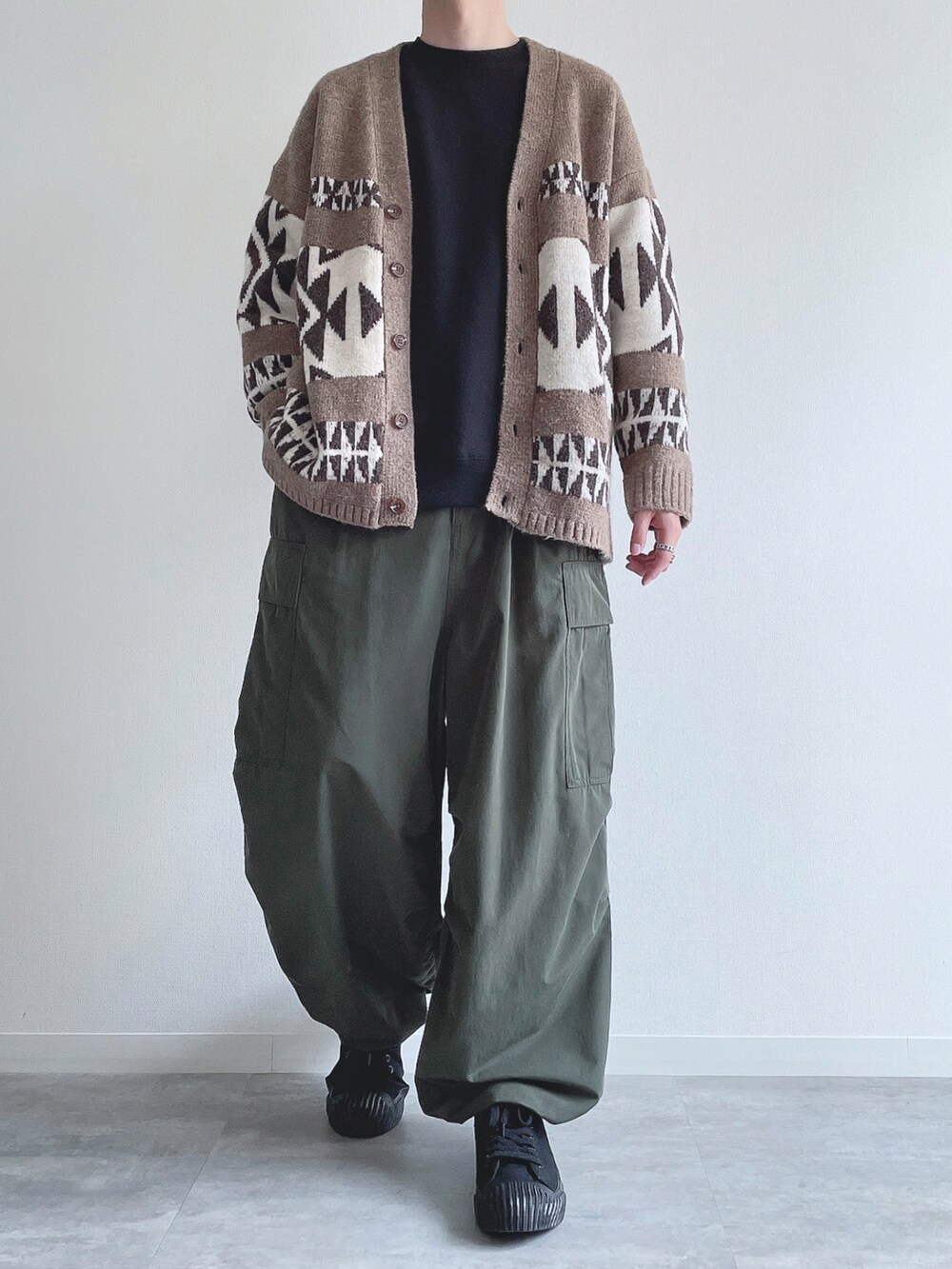 ベージュ系のカーディガン/ボレロ、ブラック系のスウェット、グリーン系のカーゴパンツを着用したメンズの冬コーディネートの2枚目の写真