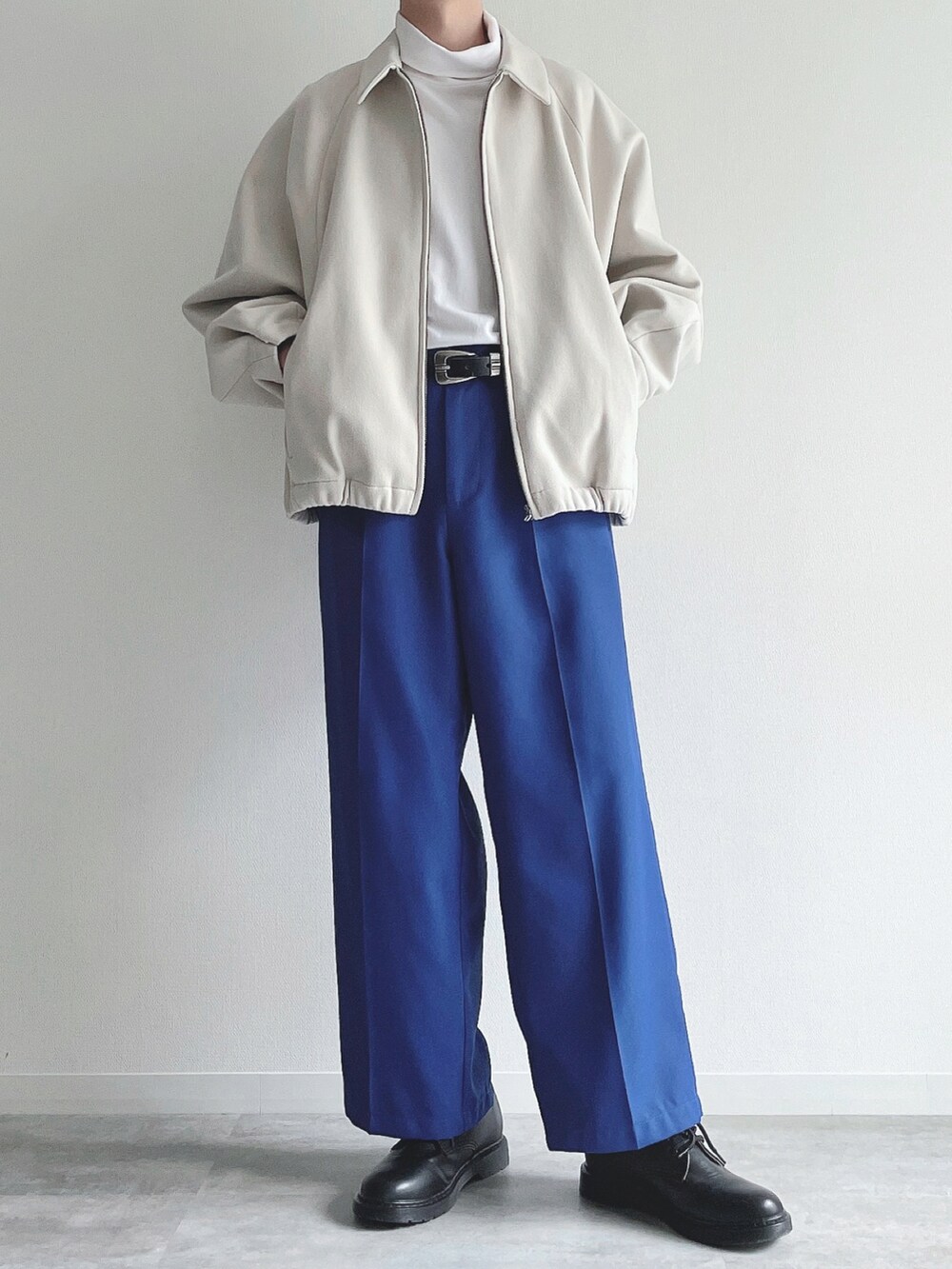 ホワイト系のブルゾン、ホワイト系のTシャツ/カットソー、ブルー系のスラックスを着用したメンズの冬コーディネートの4枚目の写真