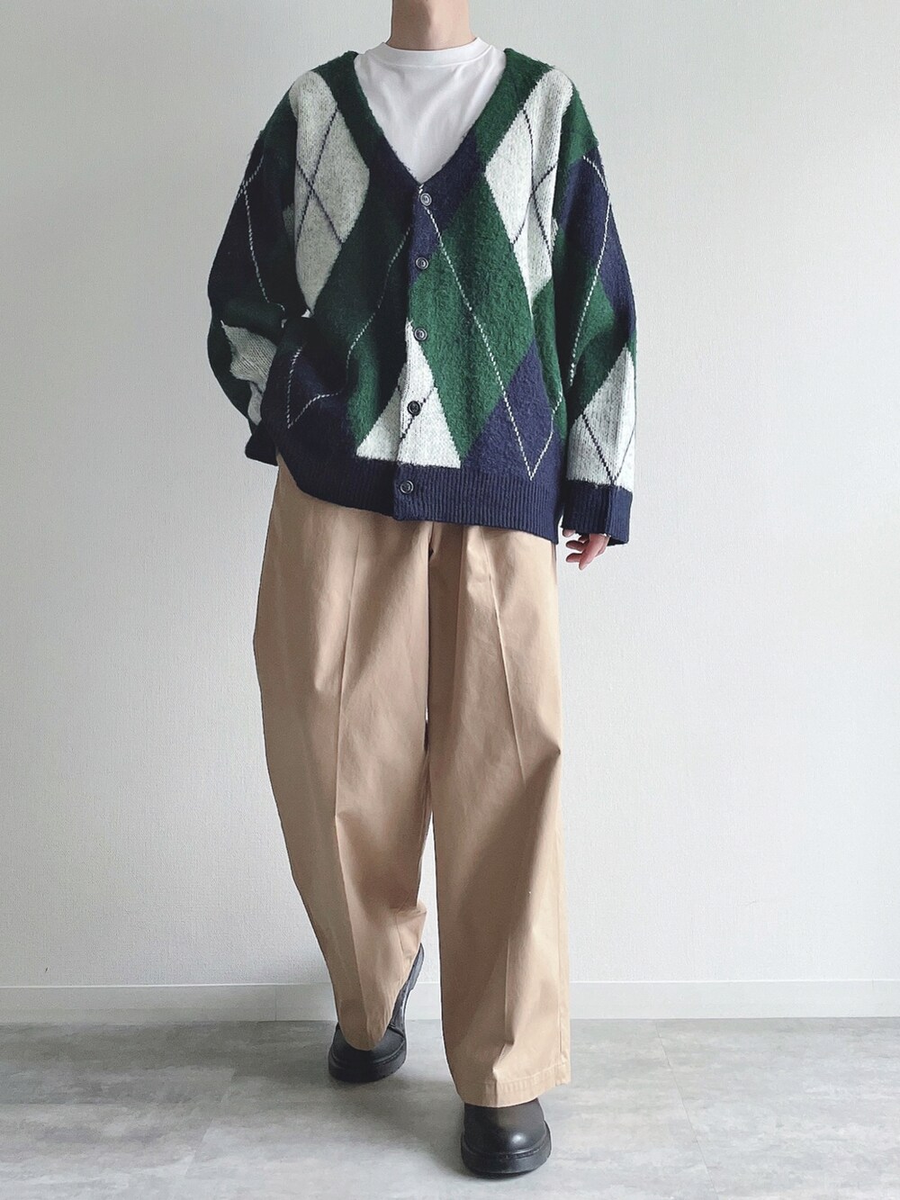 グリーン系のカーディガン/ボレロ、ホワイト系のTシャツ/カットソー、ベージュ系のチノパンツを着用したメンズの冬コーディネートの2枚目の写真