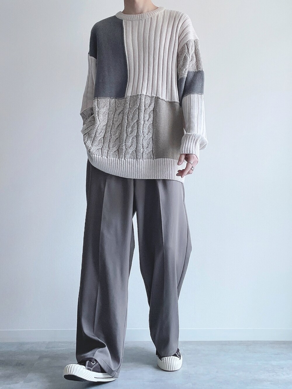 ホワイト系のニット/セーター、ベージュ系のスラックス、ブラウン系のスニーカーを着用したメンズの冬コーディネートの5枚目の写真