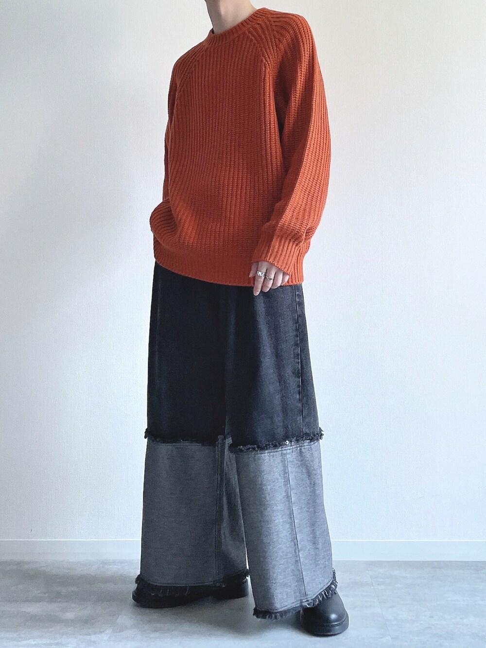オレンジ系のトップス、ブラック系のデニムパンツ、ブラック系のスニーカーを着用したメンズの冬コーディネートの4枚目の写真