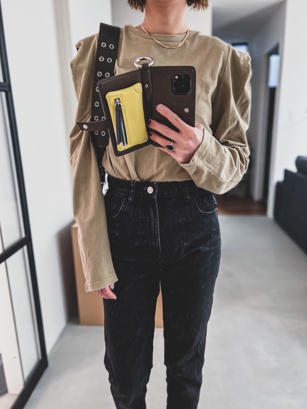 ベージュ系のTシャツ/カットソー、ブラック系のデニムパンツ、グリーン系のショルダーバッグを着用したレディースの春コーディネートの2枚目の写真