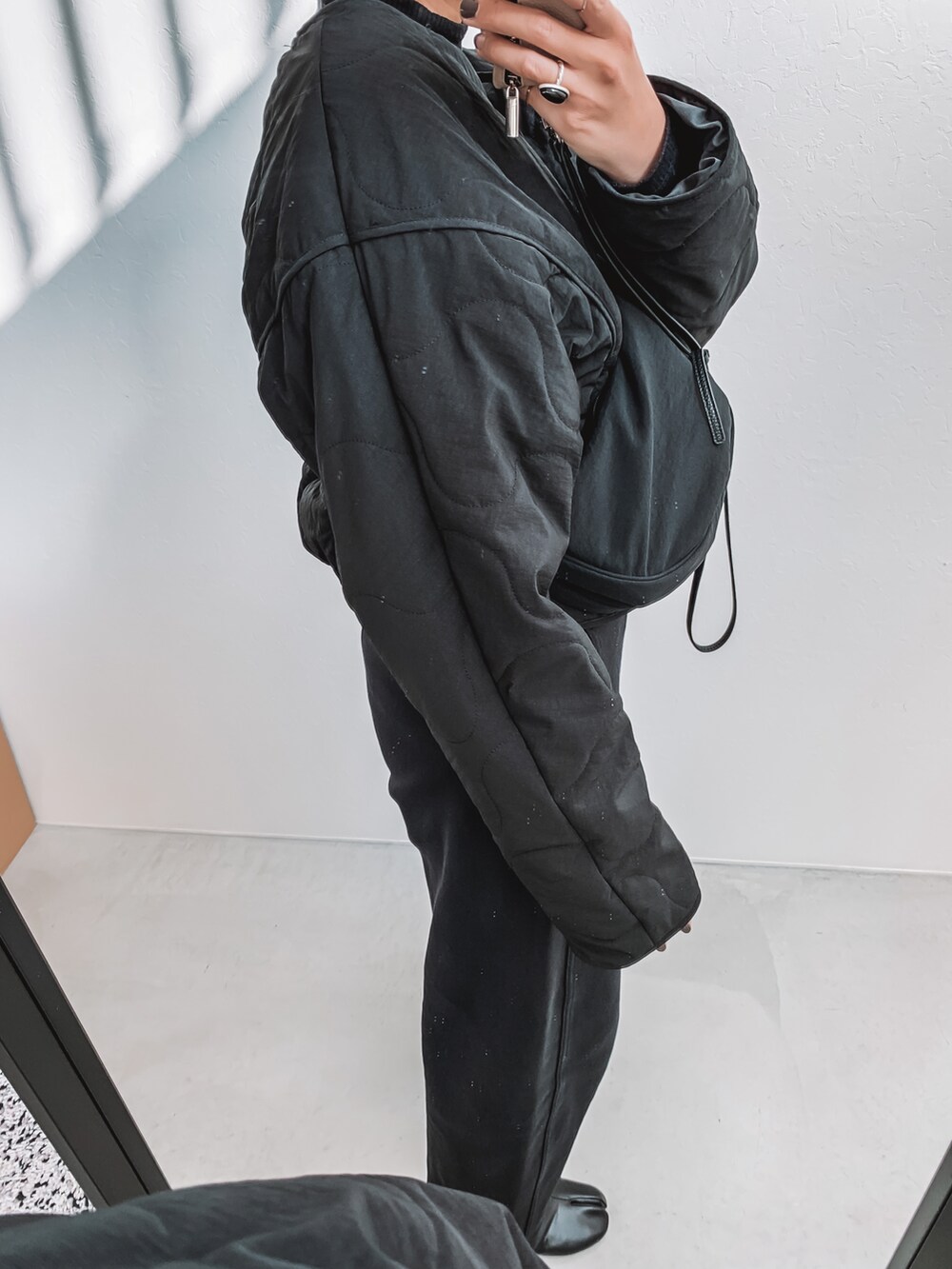 ブラック系のダウンジャケット/コート、ブラック系のその他パンツ、ブラック系のブーツを着用したレディースの冬コーディネートの2枚目の写真