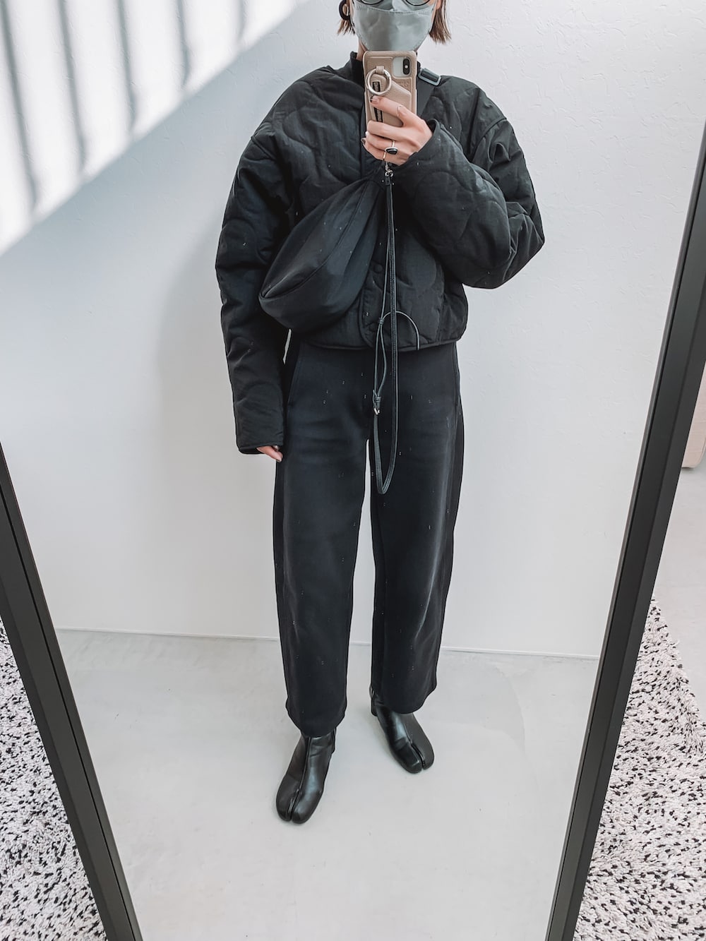 ブラック系のダウンジャケット/コート、ブラック系のその他パンツ、ブラック系のブーツを着用したレディースの冬コーディネートの5枚目の写真