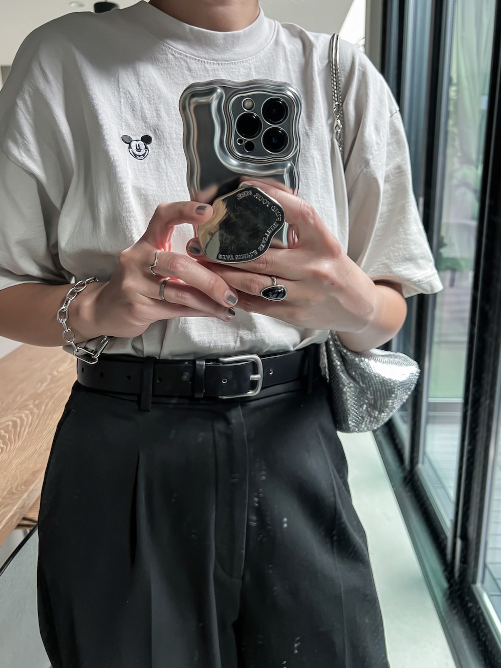 グレー系のTシャツ/カットソー、ブラック系のパンツ、シルバー系のショルダーバッグを着用したレディースの夏コーディネートの2枚目の写真