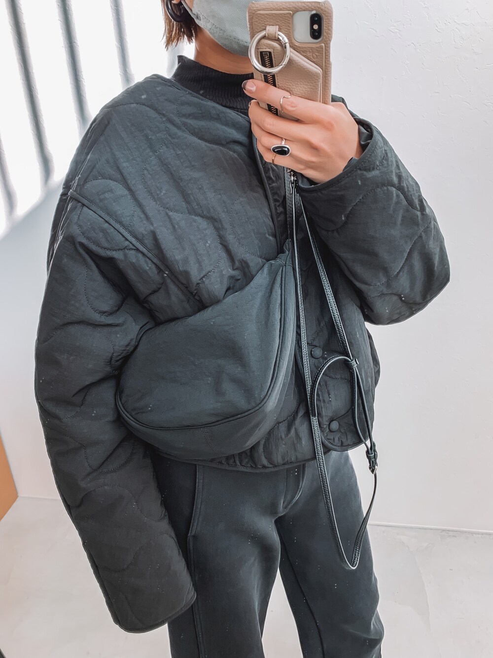 ブラック系のダウンジャケット/コート、ブラック系のその他パンツ、ブラック系のブーツを着用したレディースの冬コーディネートの3枚目の写真