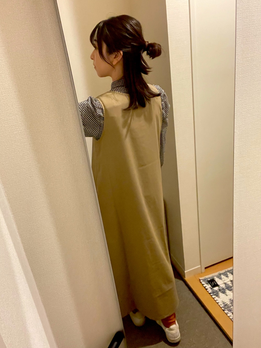 ホワイト系のスニーカー、ベージュ系のワンピース、ブラック系のシャツ/ブラウスを着用したレディースの春コーディネートの2枚目の写真