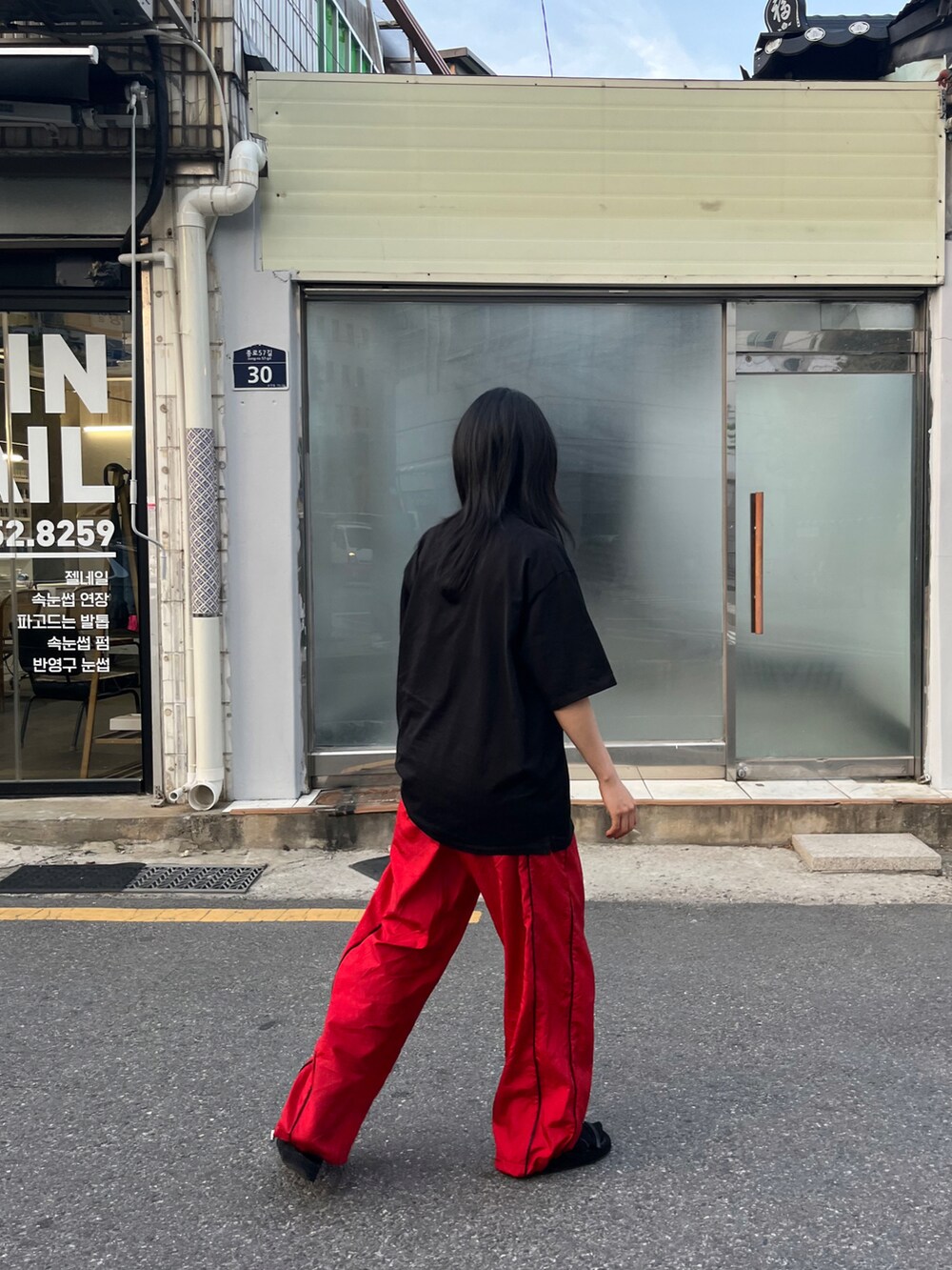 ブラック系のトップスを着用したレディースの春コーディネートの2枚目の写真