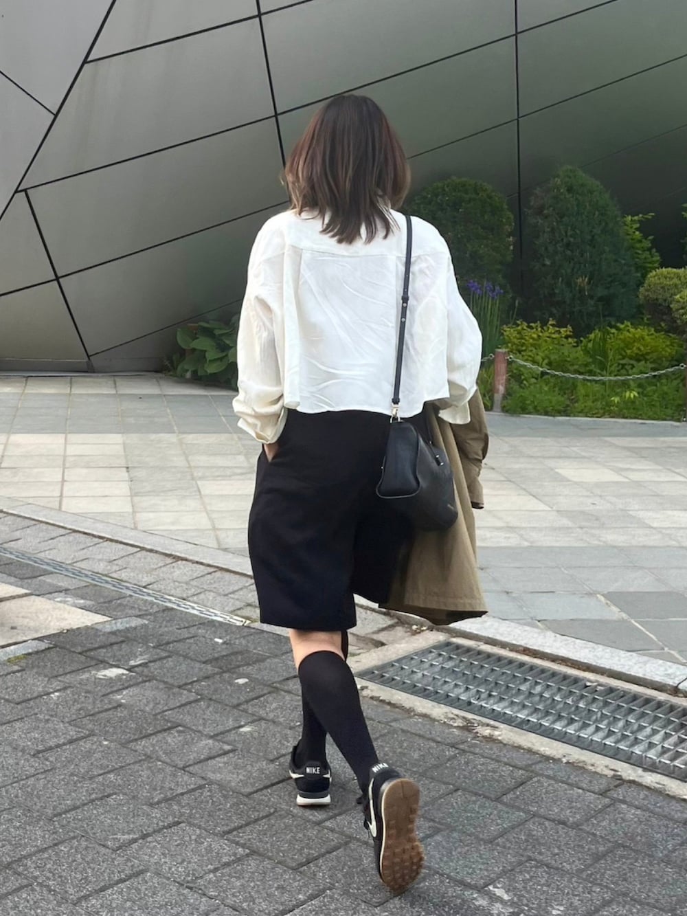 ブラック系のパンツ、ホワイト系のシャツ/ブラウス、ブラック系のスニーカーを着用したレディースの春コーディネートの2枚目の写真