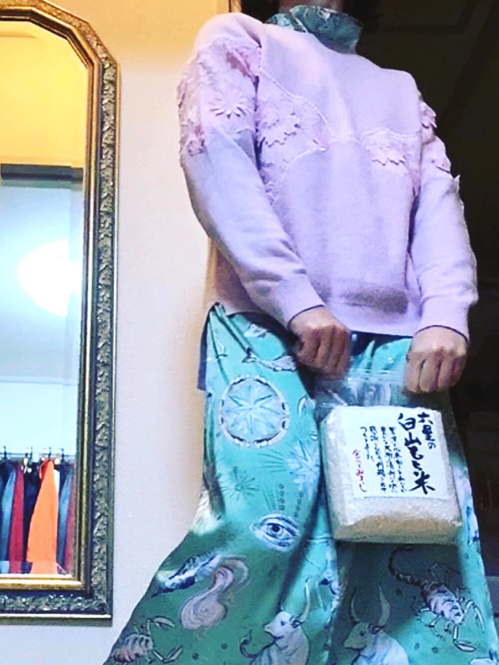 ピンク系のニット/セーター、グリーン系のワンピース、シルバー系のダウンジャケット/コートを着用したレディースの冬コーディネートの2枚目の写真