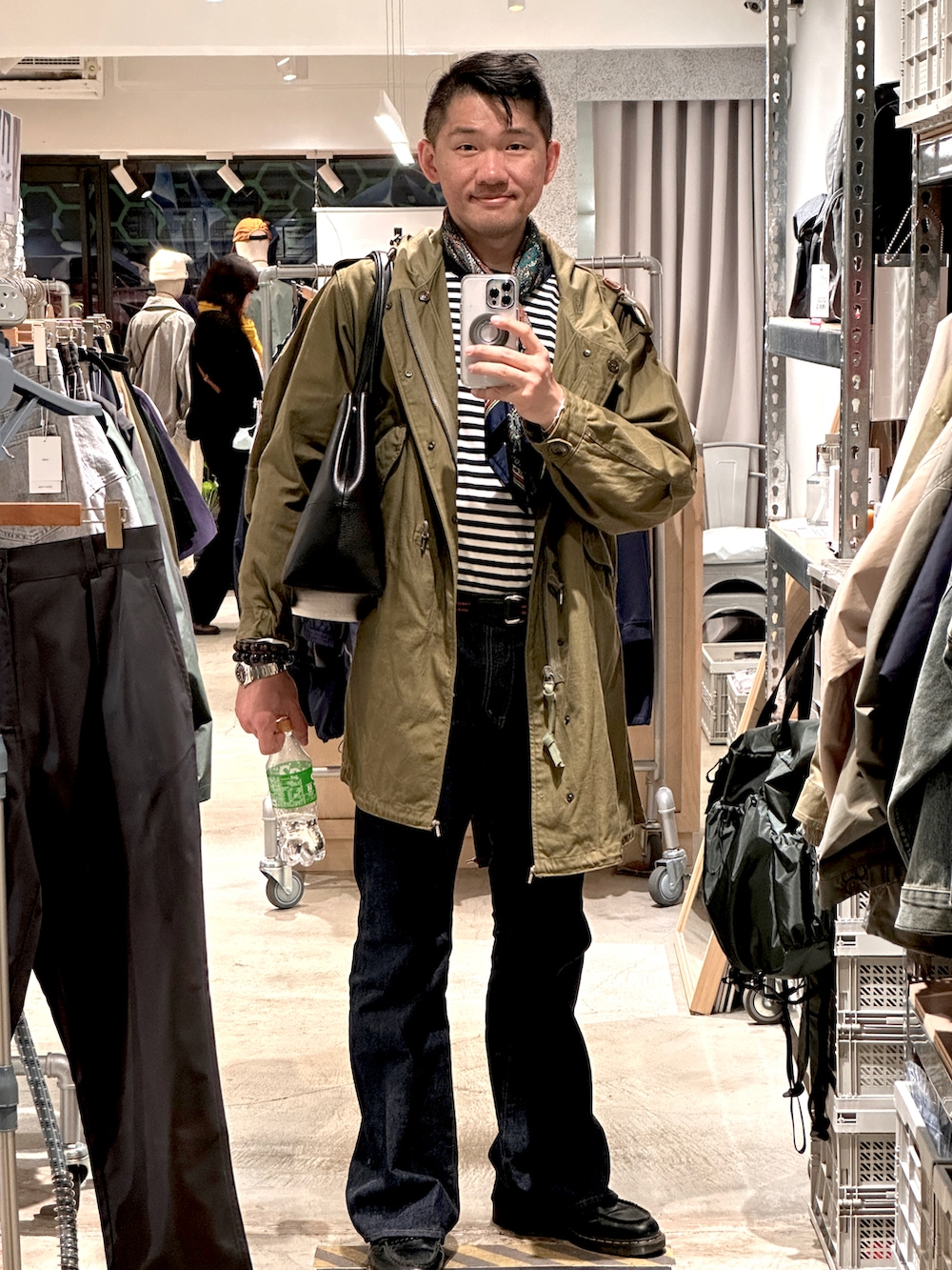 ブルー系のデニムパンツ、グリーン系のミリタリージャケット、ブラック系のローファーを着用したメンズの春コーディネートの2枚目の写真