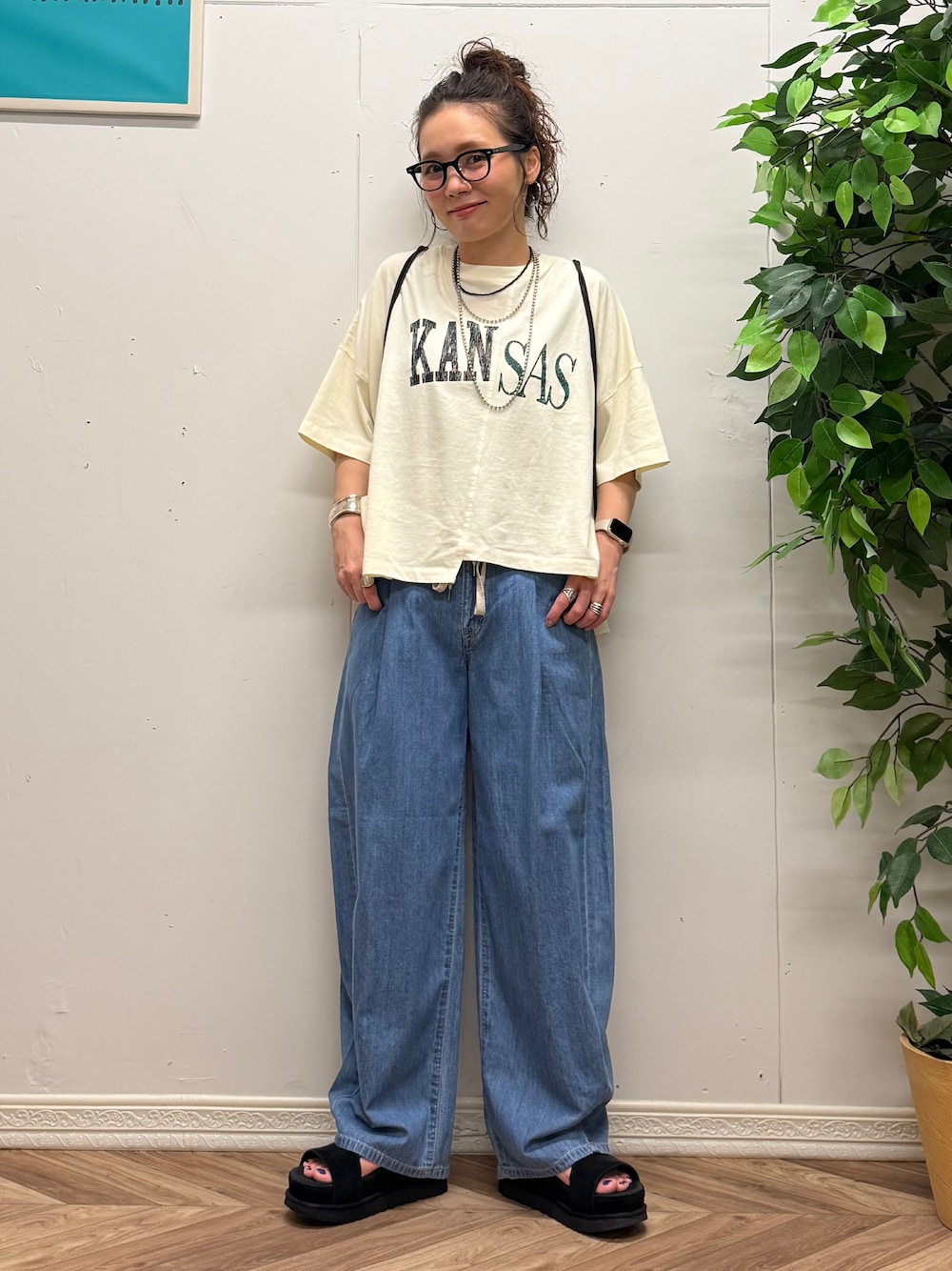 レッド系のショルダーバッグ、ホワイト系のTシャツ/カットソー、ブルー系のデニムパンツを着用したレディースの夏コーディネートの4枚目の写真