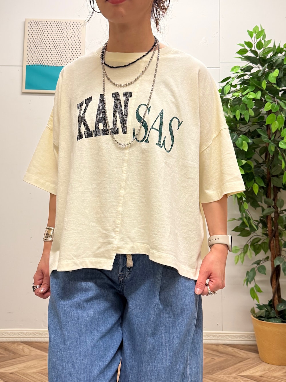 レッド系のショルダーバッグ、ホワイト系のTシャツ/カットソー、ブルー系のデニムパンツを着用したレディースの夏コーディネートの5枚目の写真