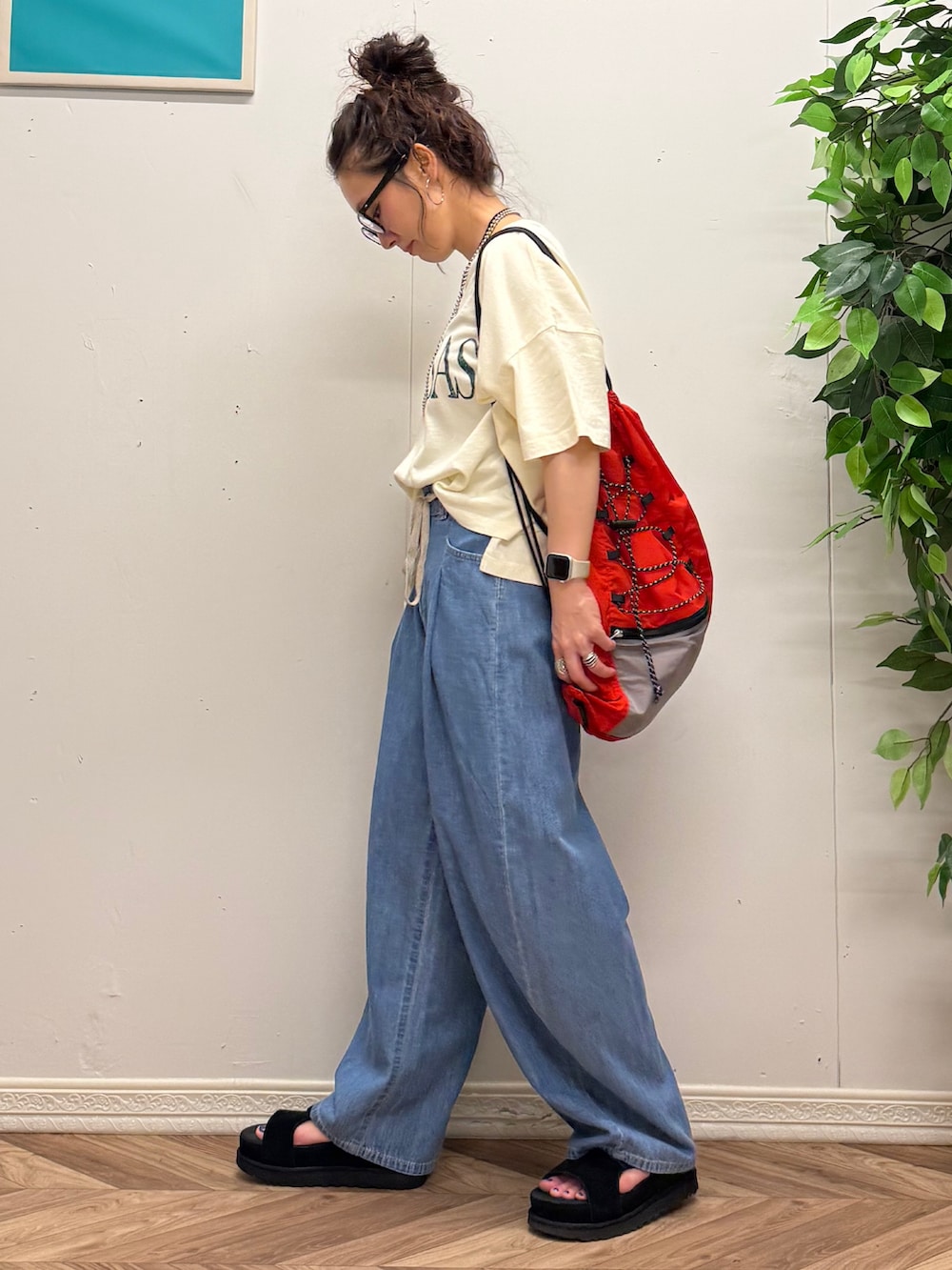レッド系のショルダーバッグ、ホワイト系のTシャツ/カットソー、ブルー系のデニムパンツを着用したレディースの夏コーディネートの2枚目の写真