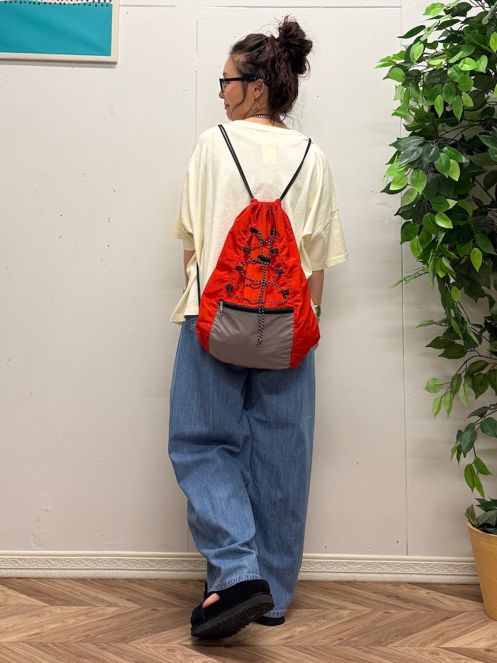 レッド系のショルダーバッグ、ホワイト系のTシャツ/カットソー、ブルー系のデニムパンツを着用したレディースの夏コーディネートの3枚目の写真