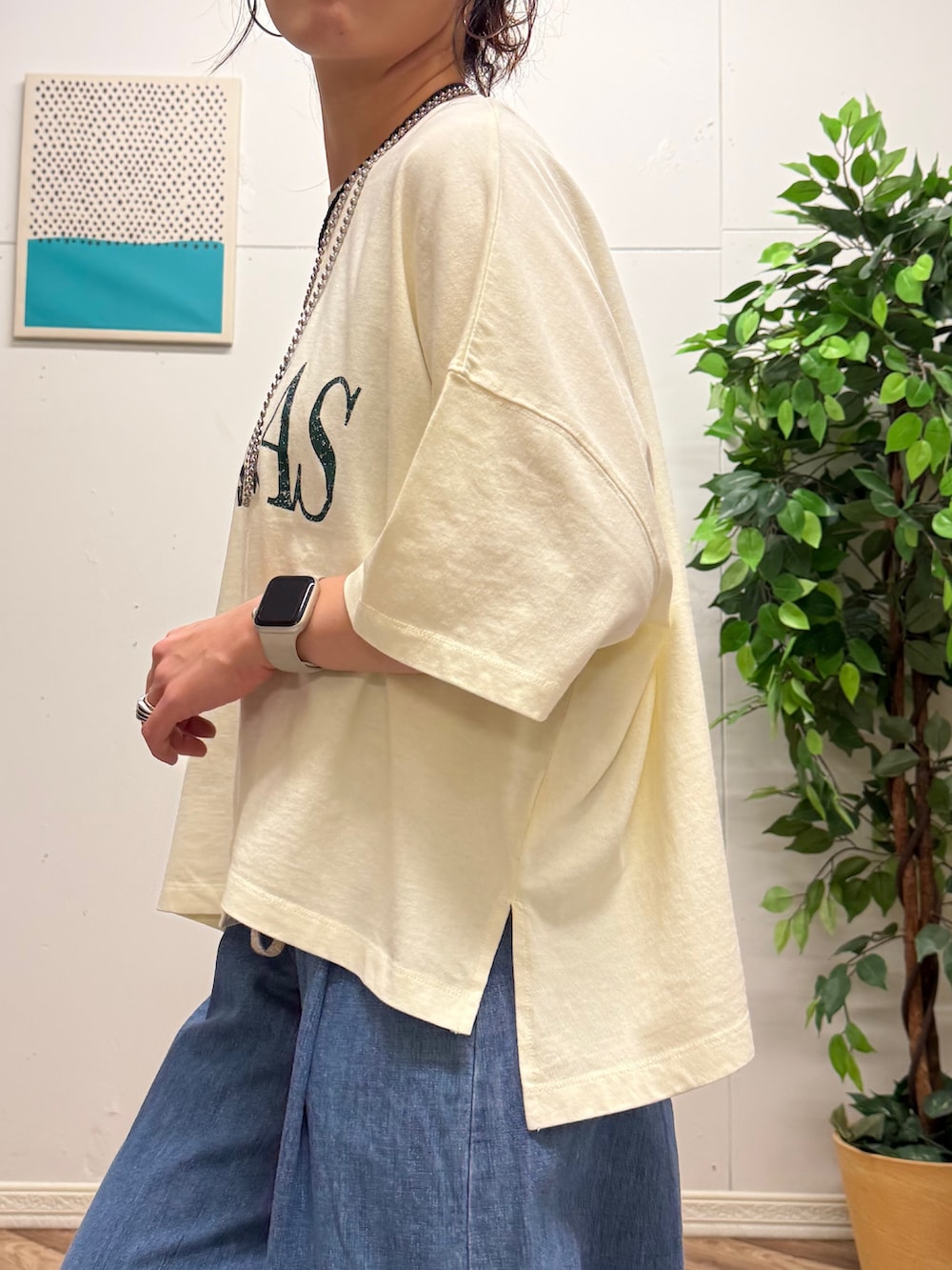 レッド系のショルダーバッグ、ホワイト系のTシャツ/カットソー、ブルー系のデニムパンツを着用したレディースの夏コーディネートの6枚目の写真