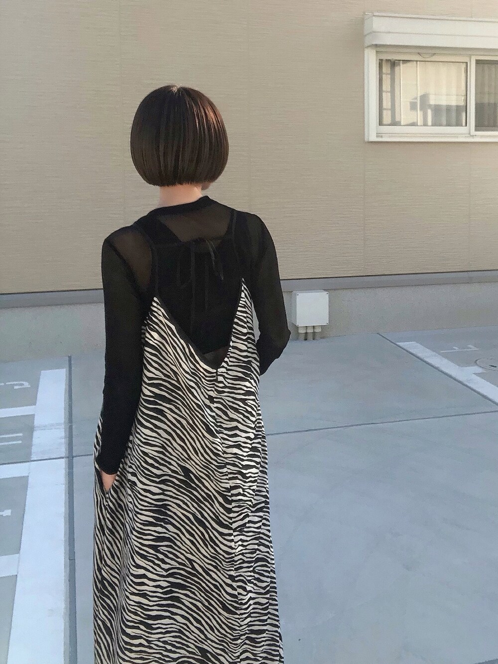 ブラック系のワンピース、ブラック系のブーツ、ブラック系のTシャツ/カットソーを着用したレディースの秋コーディネートの5枚目の写真