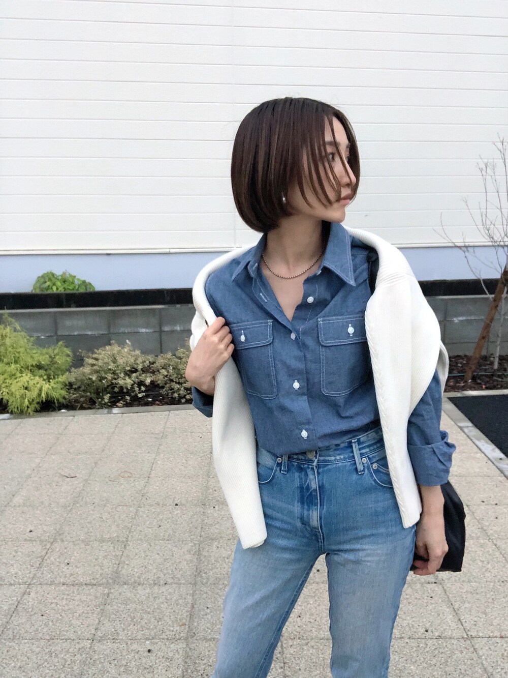 ブルー系のデニムパンツ、ブルー系のシャツ/ブラウス、ブラック系のショルダーバッグを着用したレディースの秋コーディネートの3枚目の写真