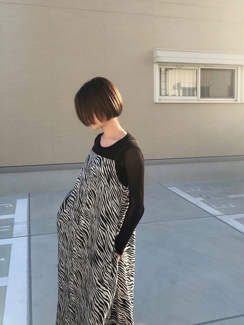 ブラック系のワンピース、ブラック系のブーツ、ブラック系のTシャツ/カットソーを着用したレディースの秋コーディネートの4枚目の写真