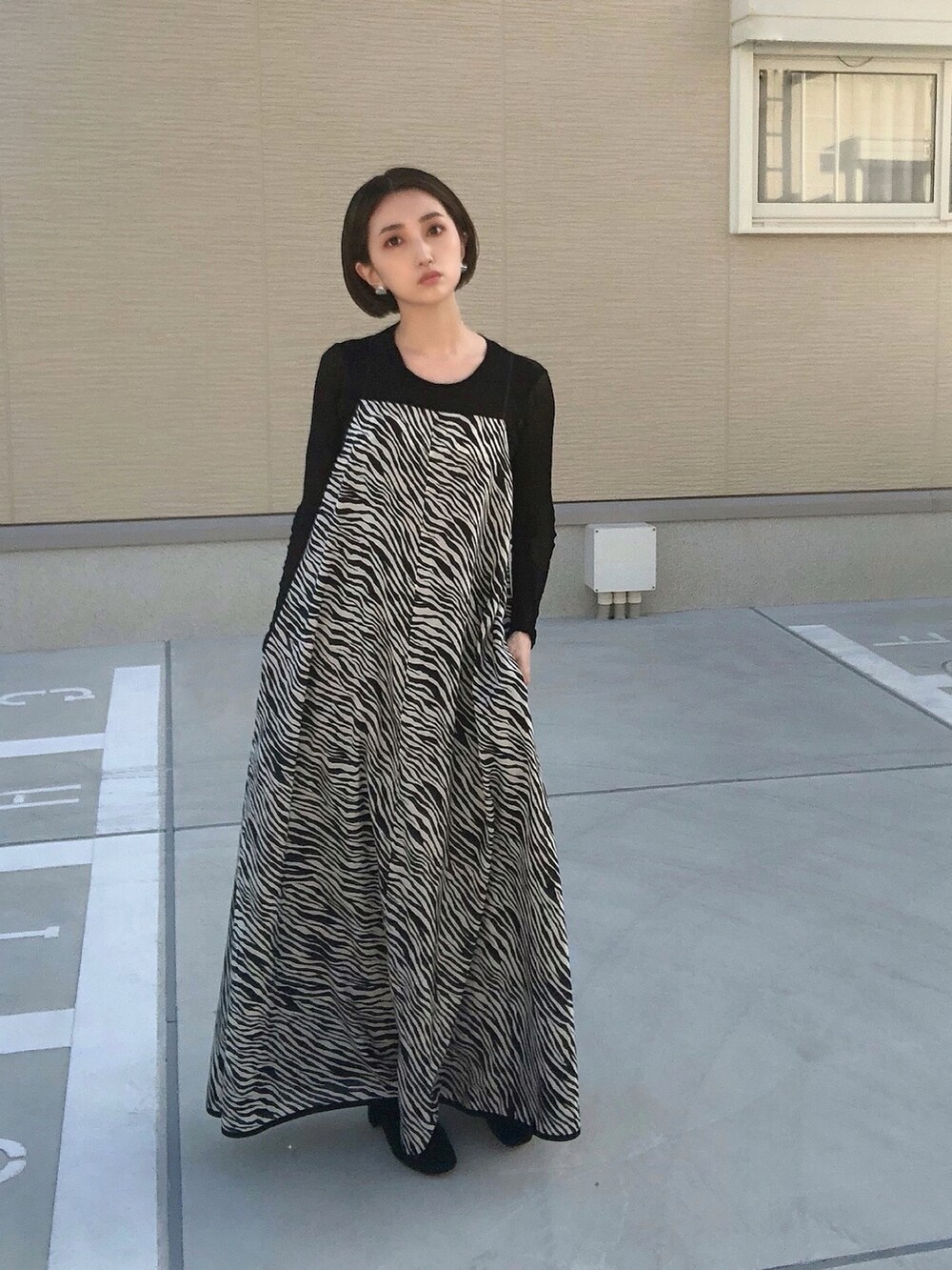 ブラック系のワンピース、ブラック系のブーツ、ブラック系のTシャツ/カットソーを着用したレディースの秋コーディネートの3枚目の写真