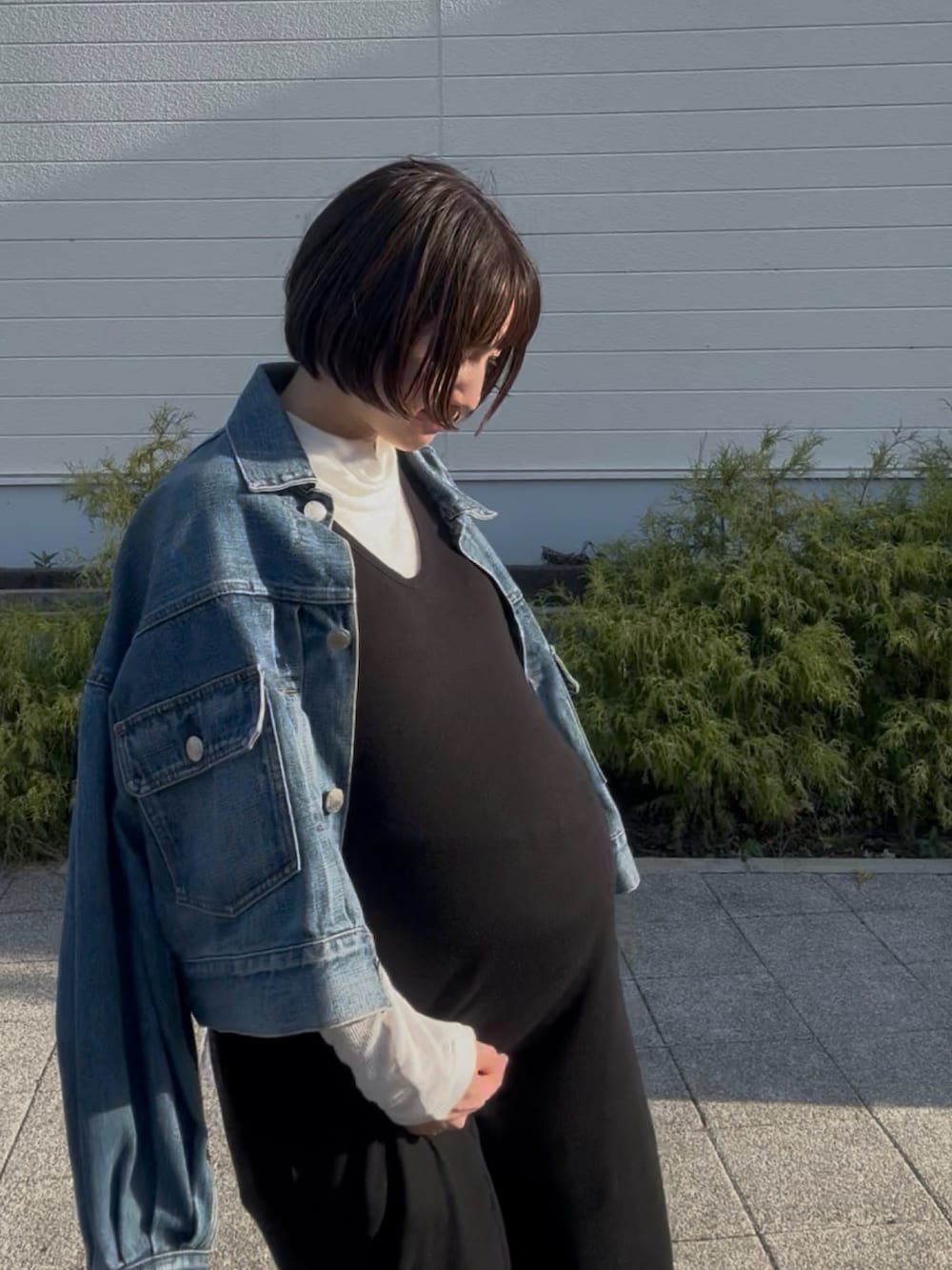 グレー系のモカシン/デッキシューズ、ブルー系のデニムジャケット、ブラック系のワンピースを着用したレディースの秋コーディネートの3枚目の写真