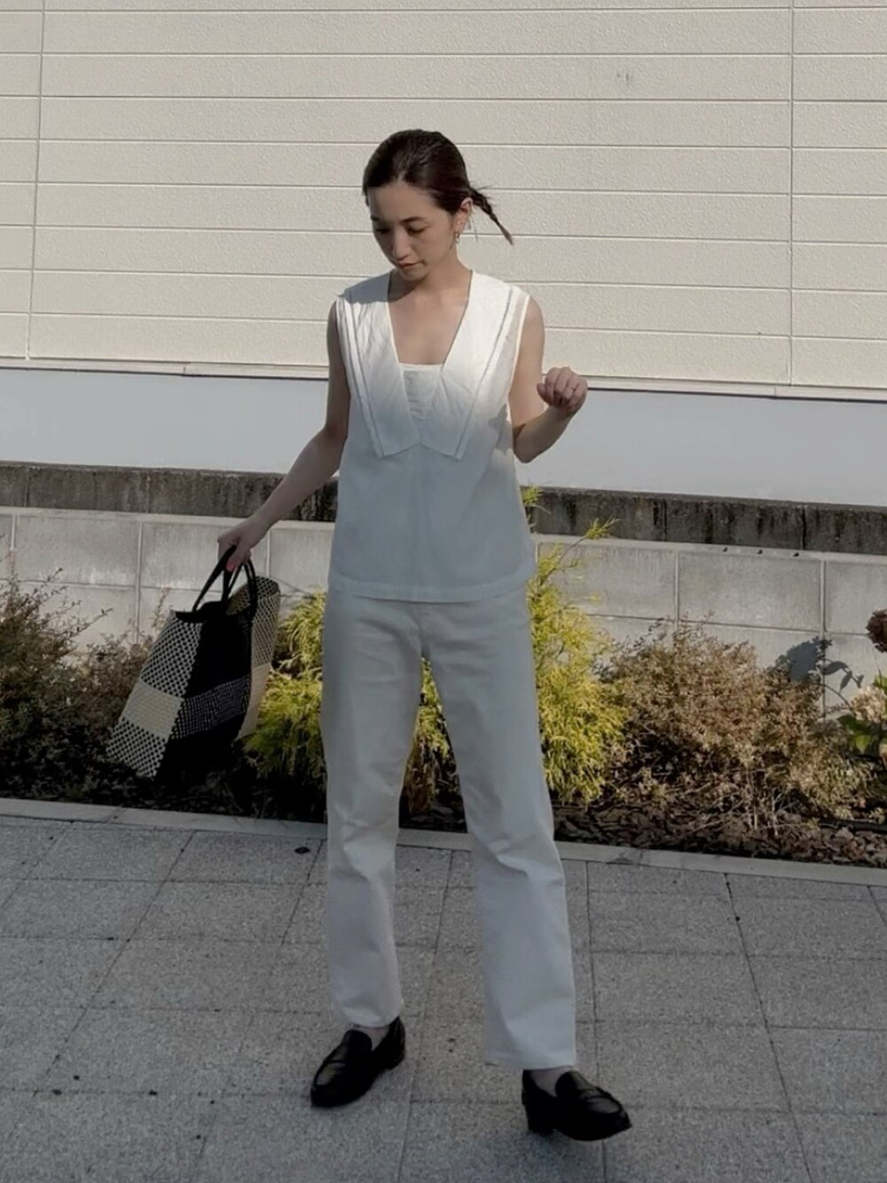 ブラック系のかごバッグ、ホワイト系のシャツ/ブラウス、ブラック系のローファーを着用したレディースの夏コーディネートの3枚目の写真