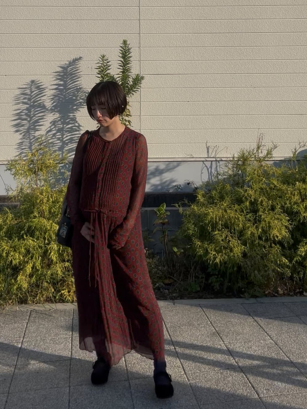 レッド系のワンピース、ブラック系のその他シューズ、ブラック系のトートバッグを着用したレディースの秋コーディネートの5枚目の写真