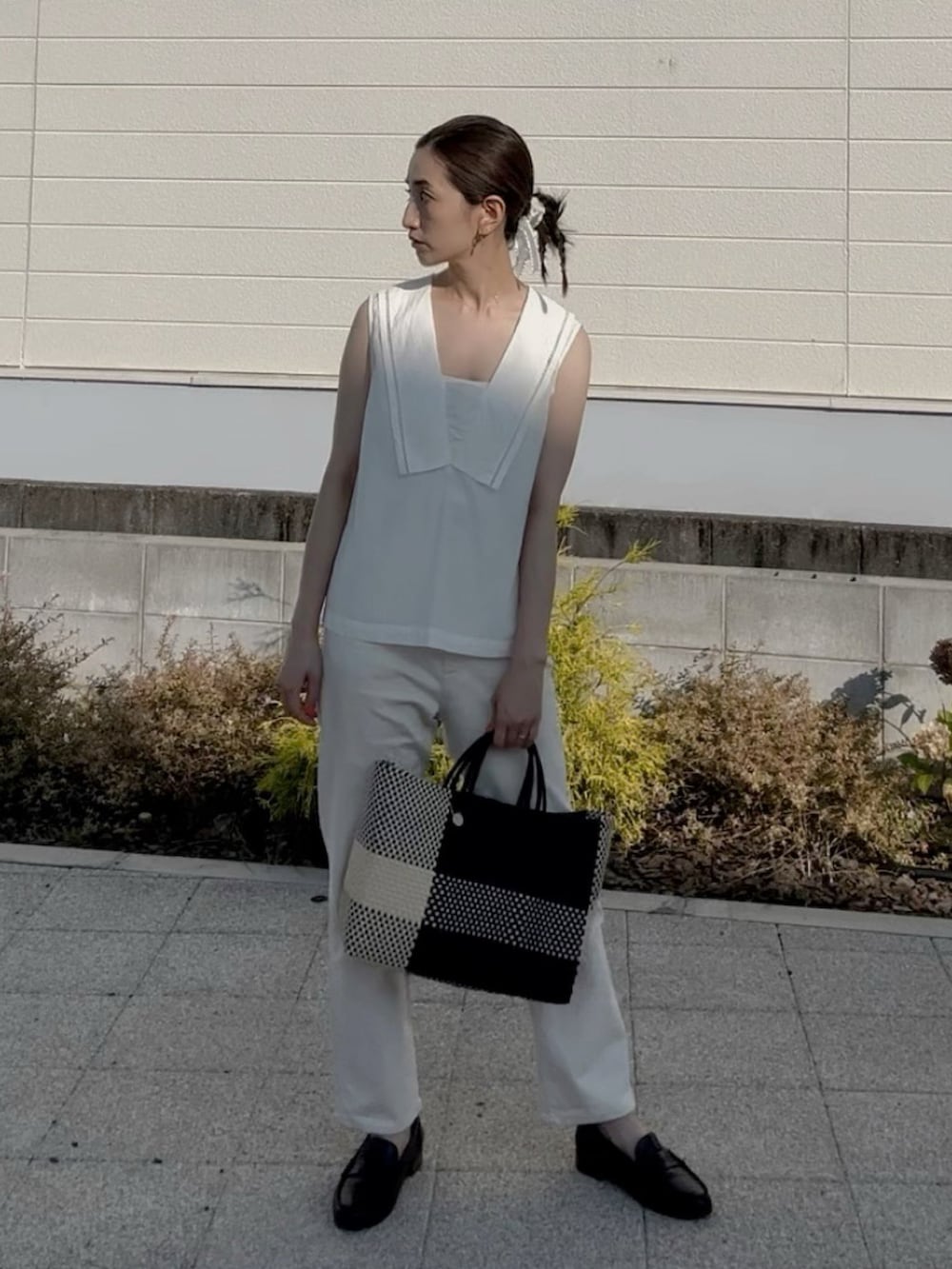 ブラック系のかごバッグ、ホワイト系のシャツ/ブラウス、ブラック系のローファーを着用したレディースの夏コーディネートの4枚目の写真