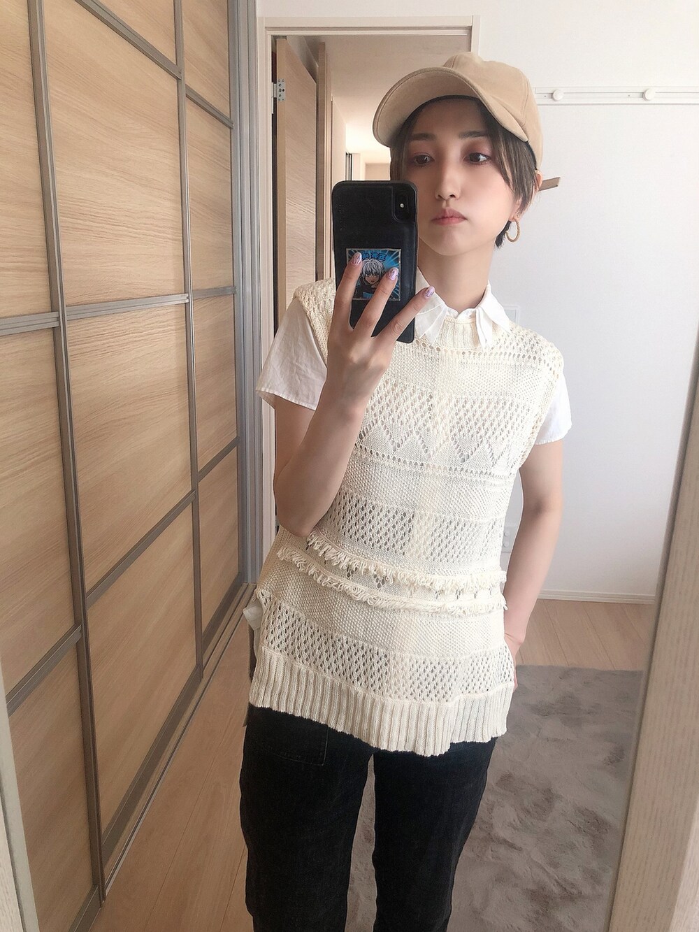 ベージュ系のニット/セーター、ブラック系のデニムパンツ、ベージュ系のキャップを着用したレディースの夏コーディネートの2枚目の写真