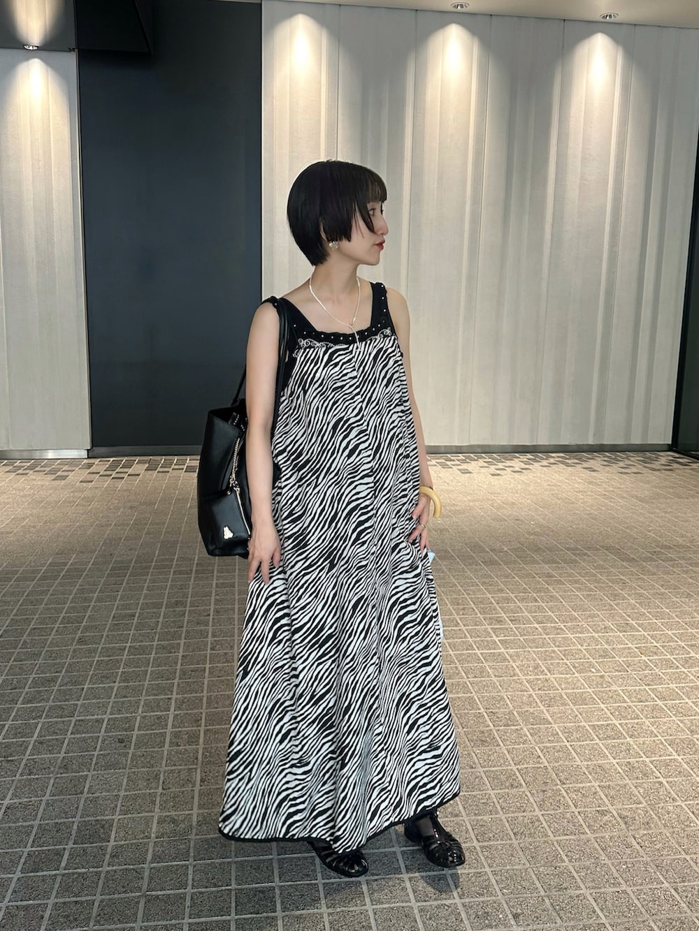 ブラック系のワンピース、ブラック系のサンダル、ブラック系のトートバッグを着用したレディースの秋コーディネートの2枚目の写真