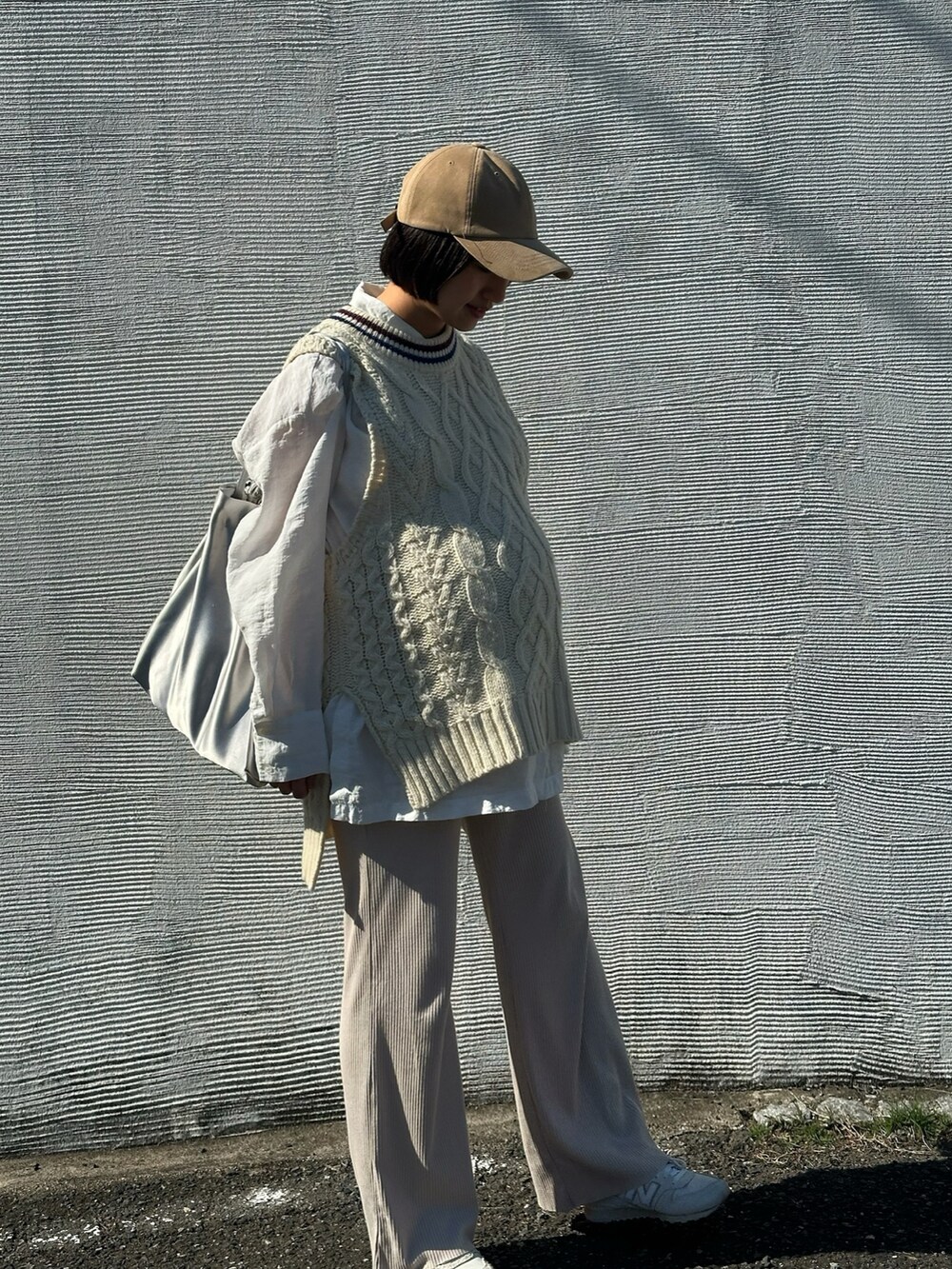 ホワイト系のニット/セーター、ホワイト系のスニーカー、ベージュ系のキャップを着用したレディースの秋コーディネートの2枚目の写真