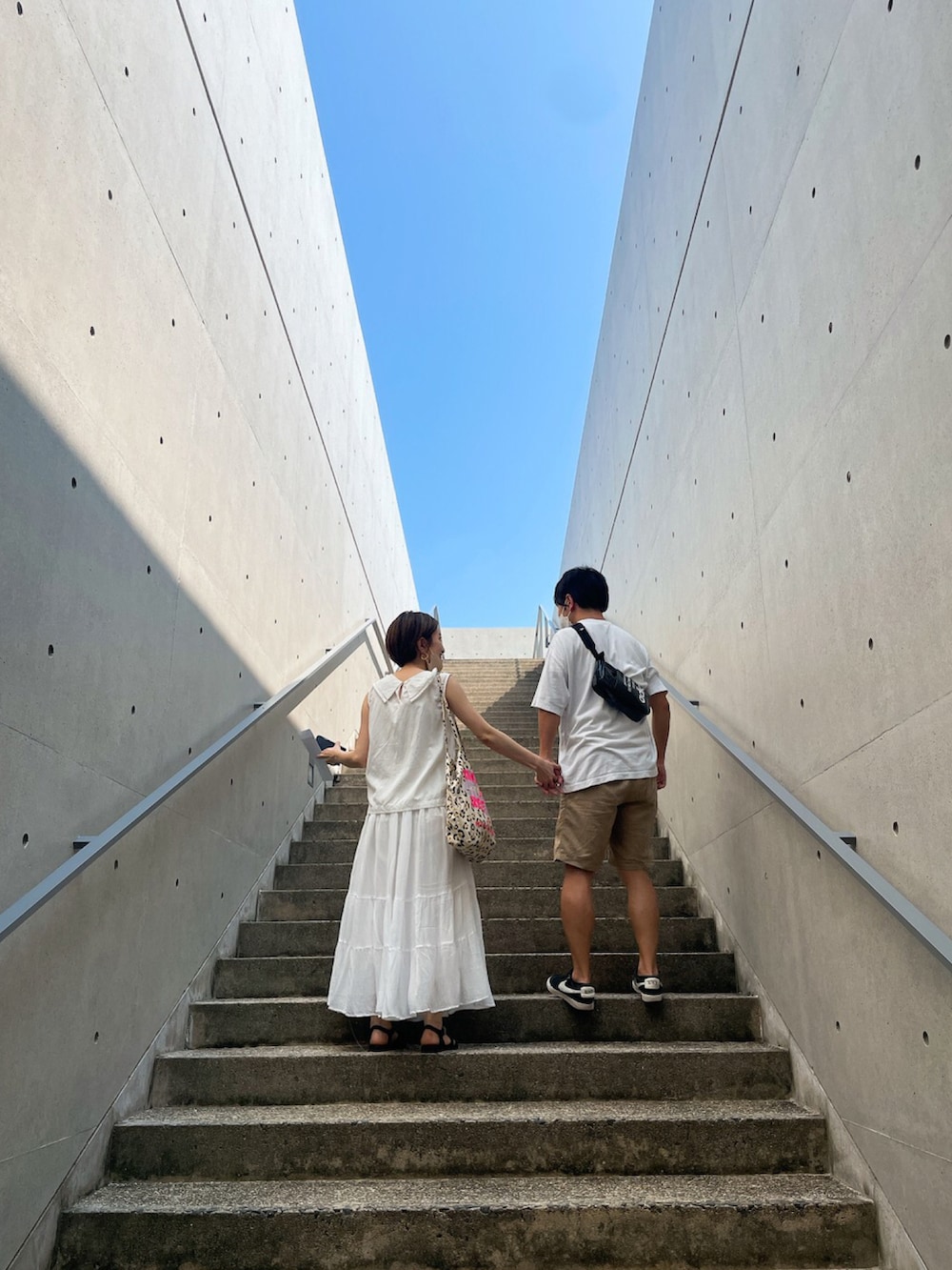 ホワイト系のシャツ/ブラウス、ホワイト系のスカート、ブラック系のサンダルを着用したレディースの夏コーディネートの2枚目の写真