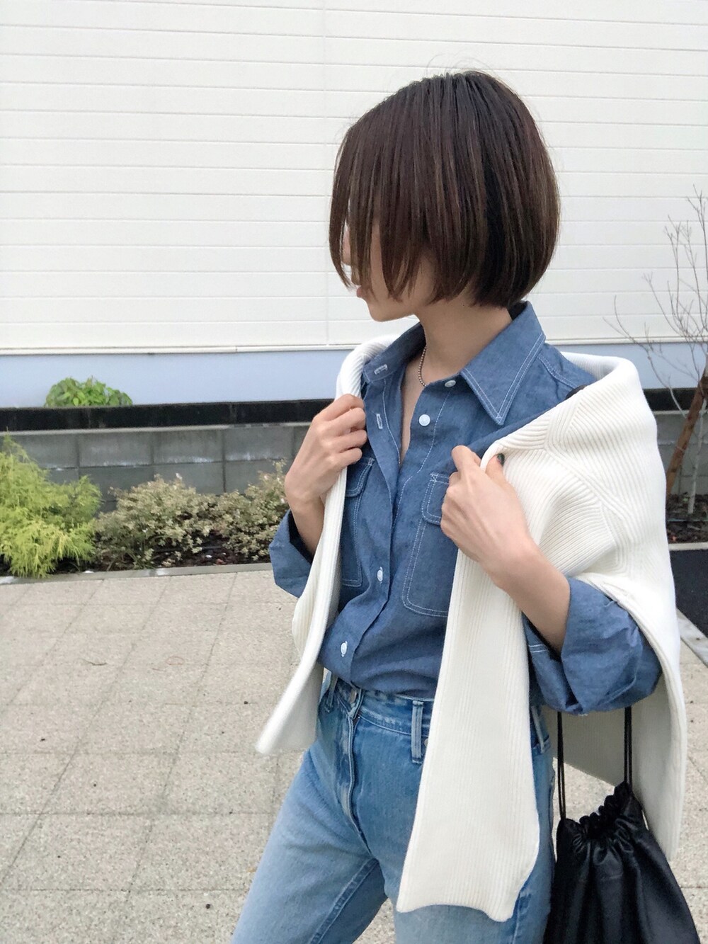 ブルー系のデニムパンツ、ブルー系のシャツ/ブラウス、ブラック系のショルダーバッグを着用したレディースの秋コーディネートの2枚目の写真