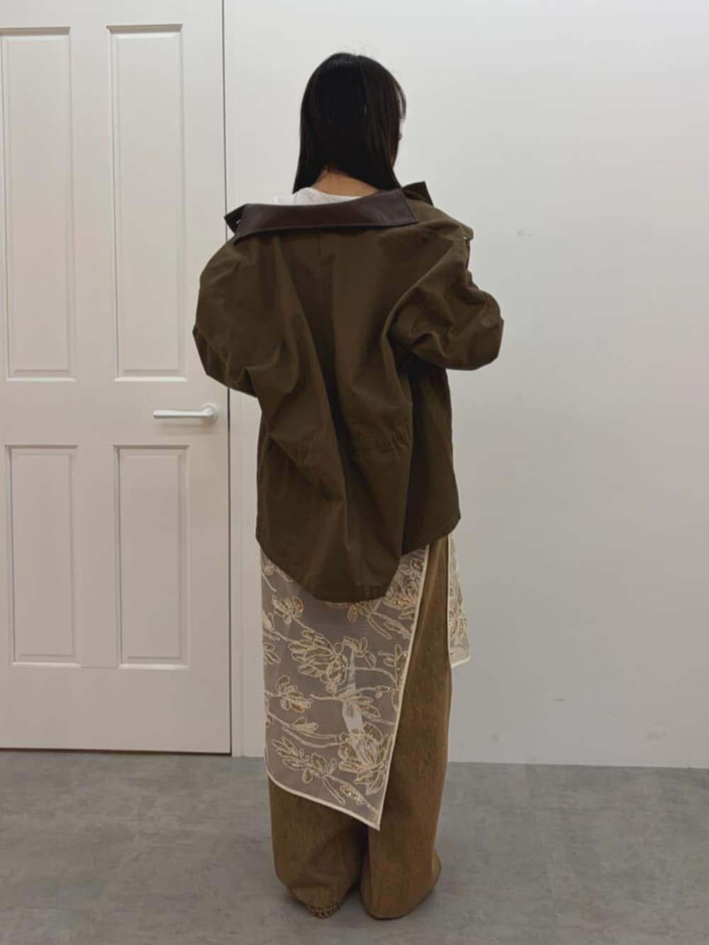 ホワイト系のスカート、ブラウン系のブルゾン、ホワイト系のTシャツ/カットソーを着用したレディースの春コーディネートの4枚目の写真