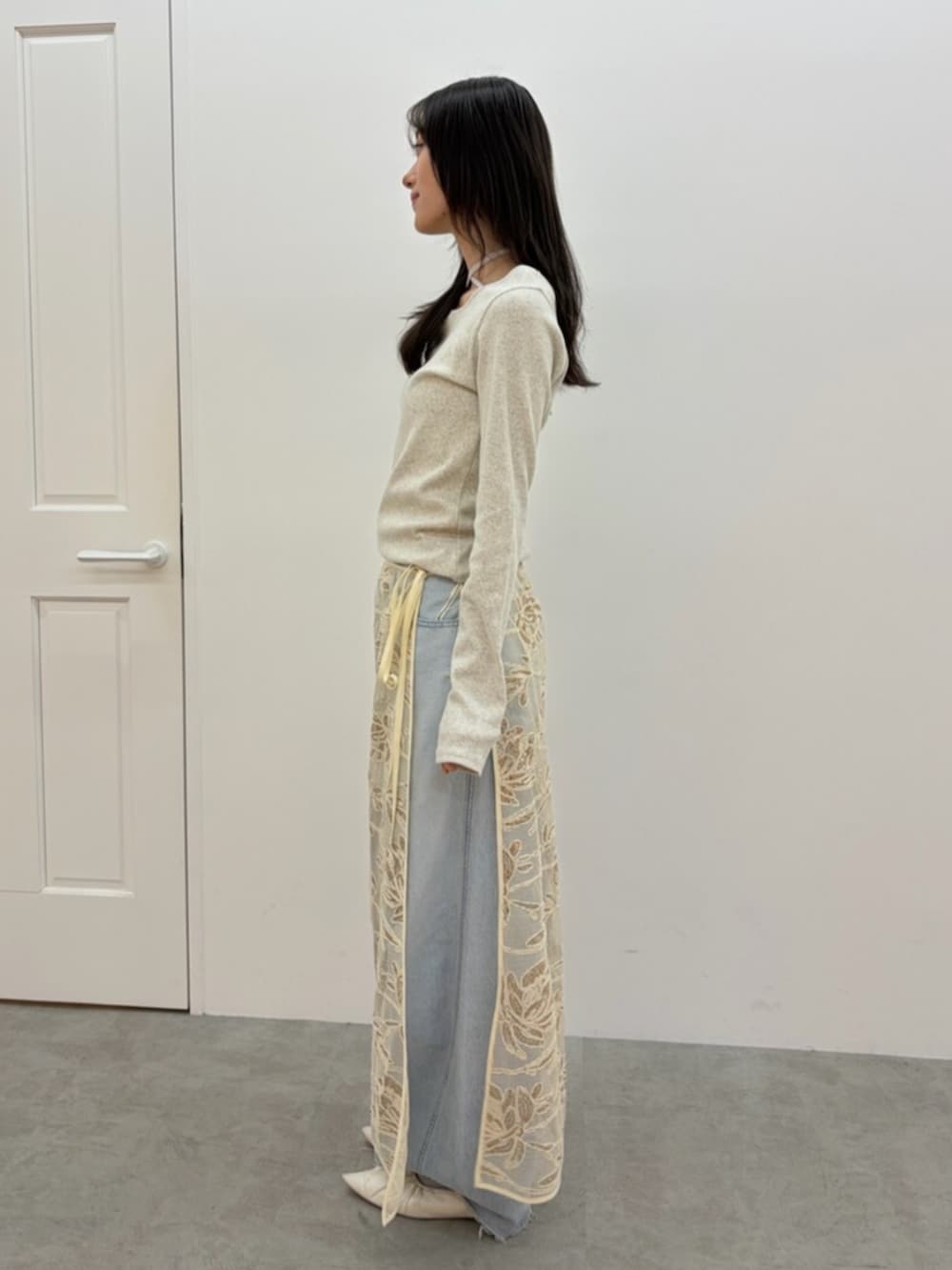 ブルー系のデニムパンツ、ホワイト系のパンプス、グレー系のTシャツ/カットソーを着用したレディースの春コーディネートの3枚目の写真