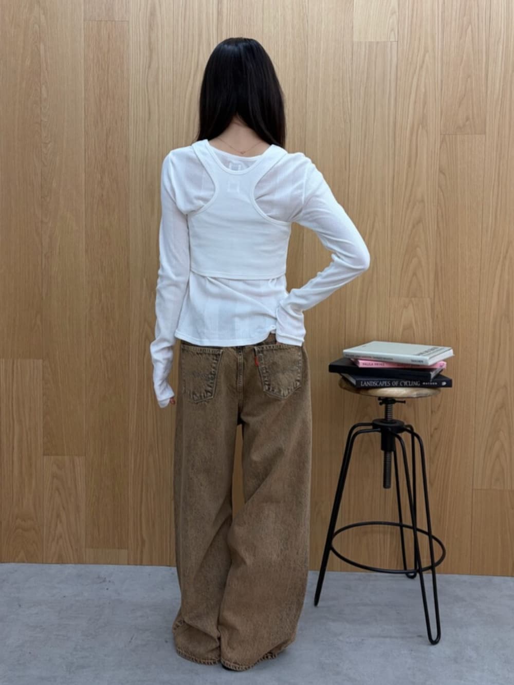 ホワイト系のTシャツ/カットソー、ブラック系のサンダル、ブラウン系のデニムパンツを着用したレディースの春コーディネートの5枚目の写真