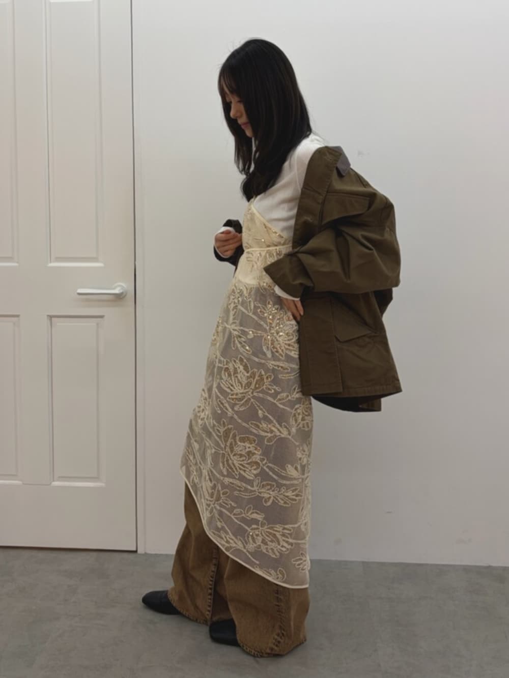 ホワイト系のスカート、ブラウン系のブルゾン、ホワイト系のTシャツ/カットソーを着用したレディースの春コーディネートの3枚目の写真