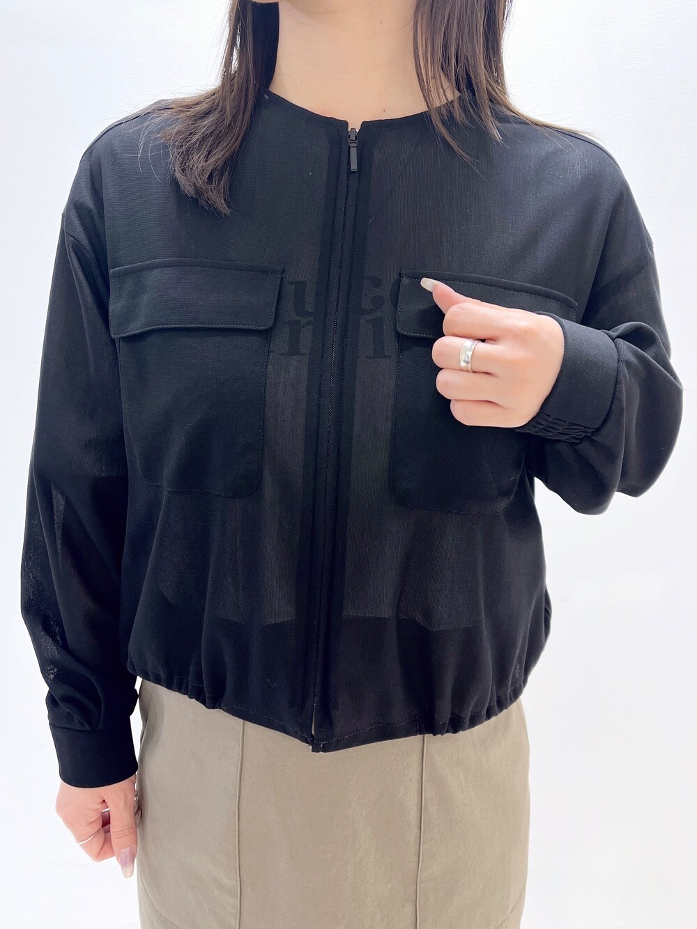 ブラック系のブルゾン、ホワイト系のTシャツ/カットソー、グリーン系のスカートを着用したレディースの春コーディネートの3枚目の写真