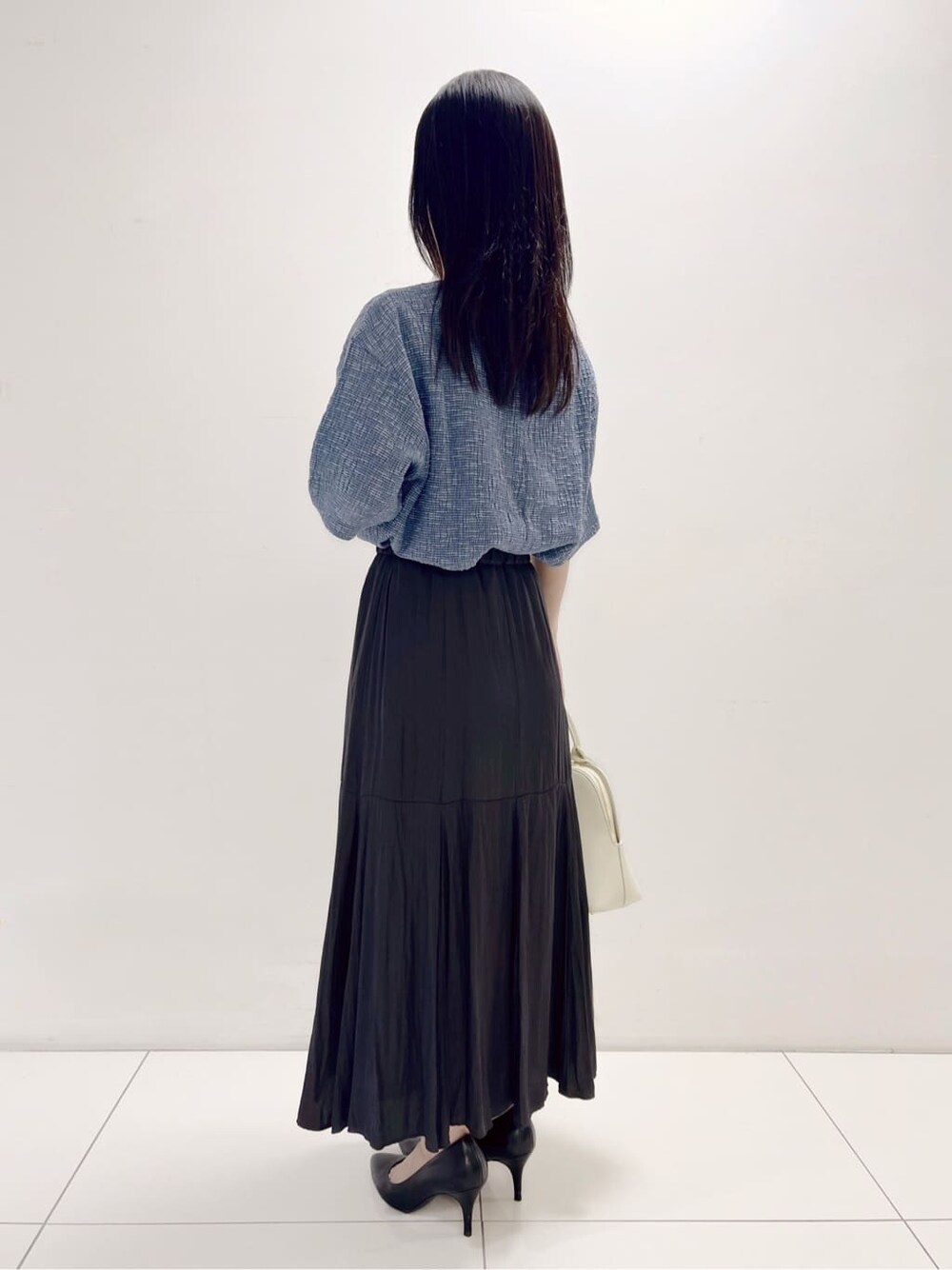 ブルー系のTシャツ/カットソー、グレー系のスカートを着用したレディースの秋コーディネートの2枚目の写真