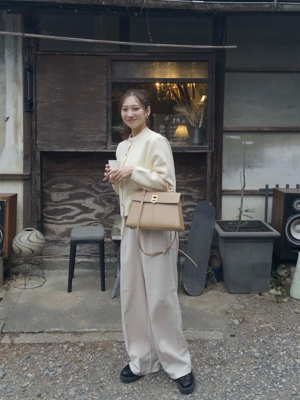 ホワイト系のカーディガン/ボレロ、ホワイト系のその他パンツ、ベージュ系のハンドバッグを着用したレディースの春コーディネートの2枚目の写真