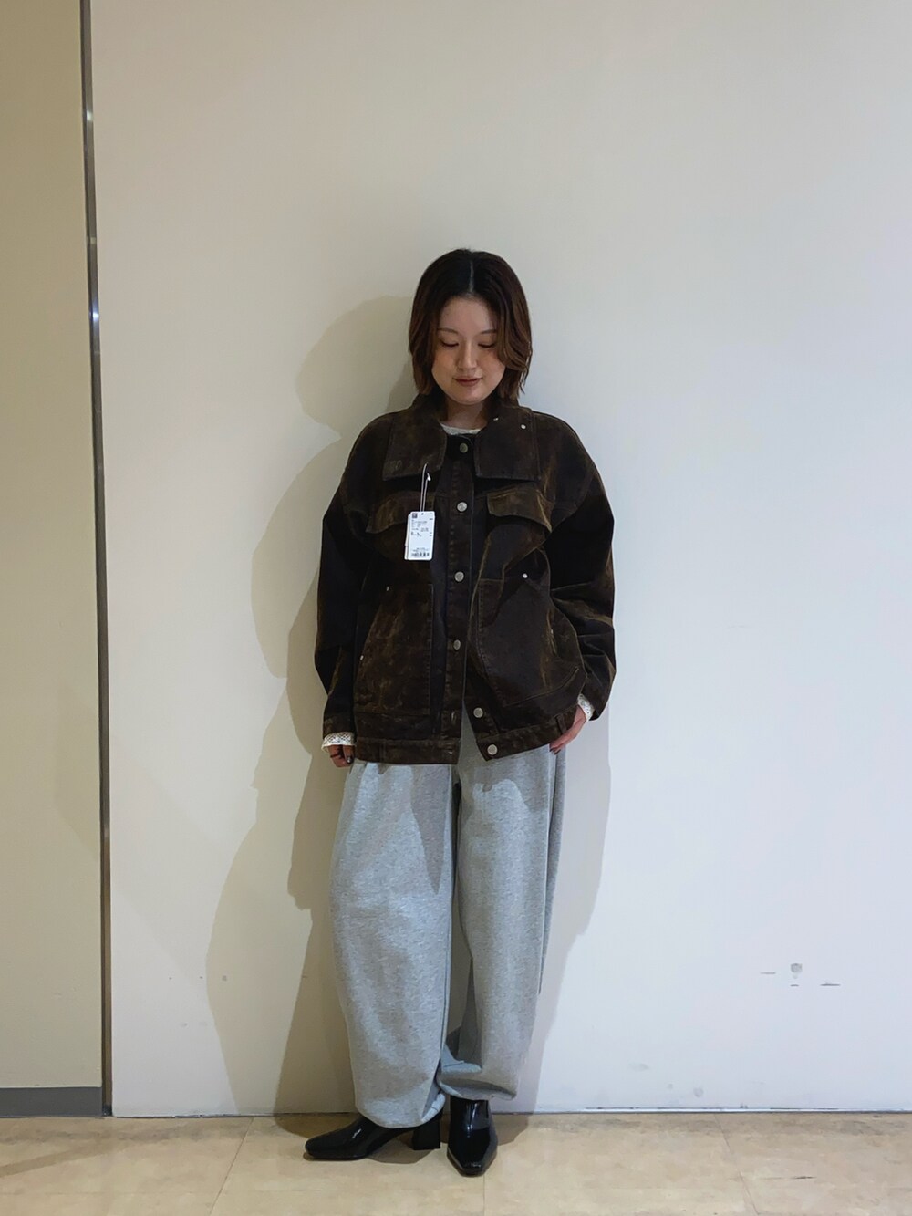 グレー系のその他パンツ、ブラック系のパンプス、ブラウン系のデニムジャケットを着用したレディースの春コーディネートの2枚目の写真