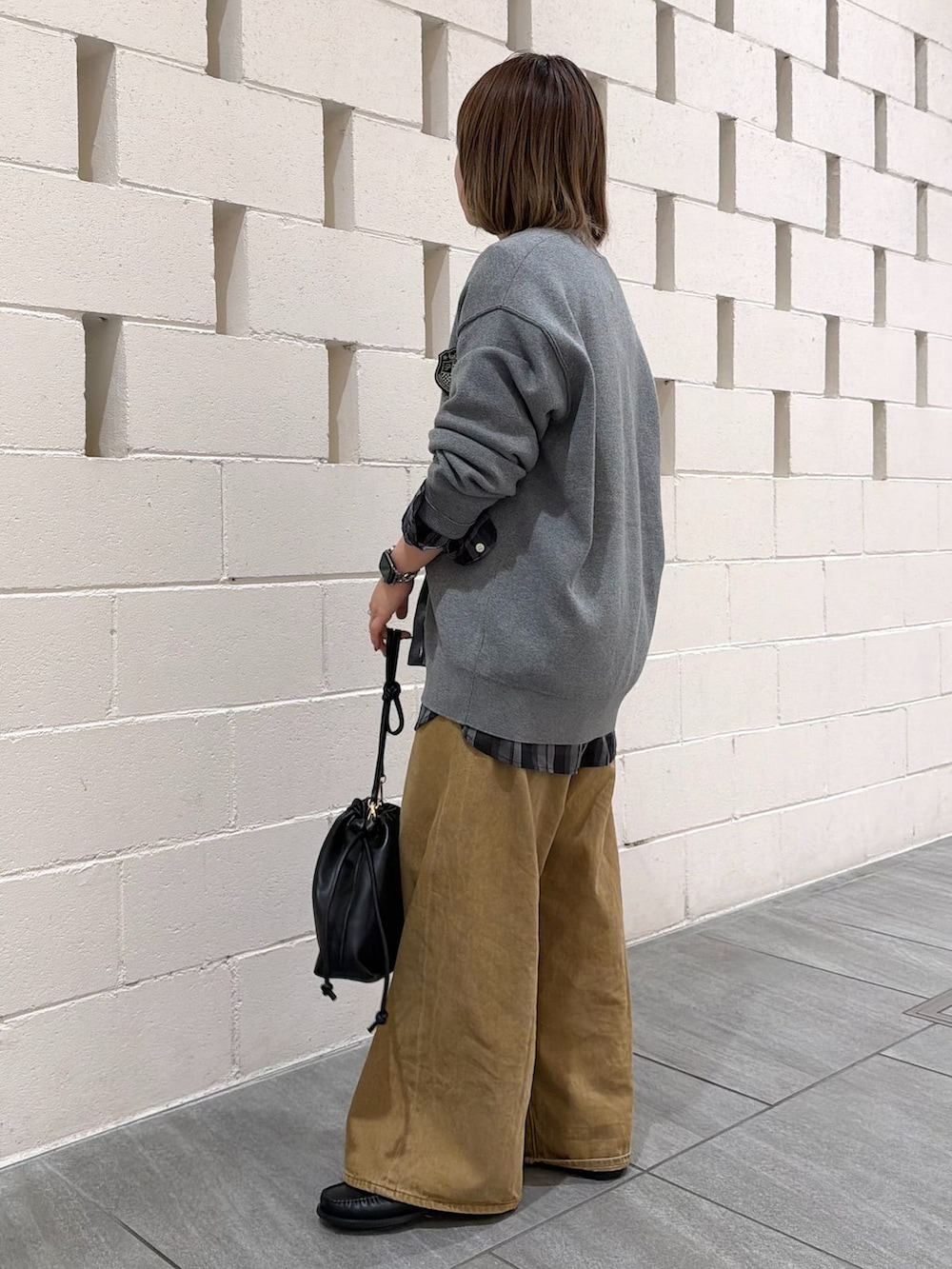 ベージュ系のデニムパンツ、ブラック系のシャツ/ブラウス、グレー系のカーディガン/ボレロを着用したレディースの秋コーディネートの2枚目の写真