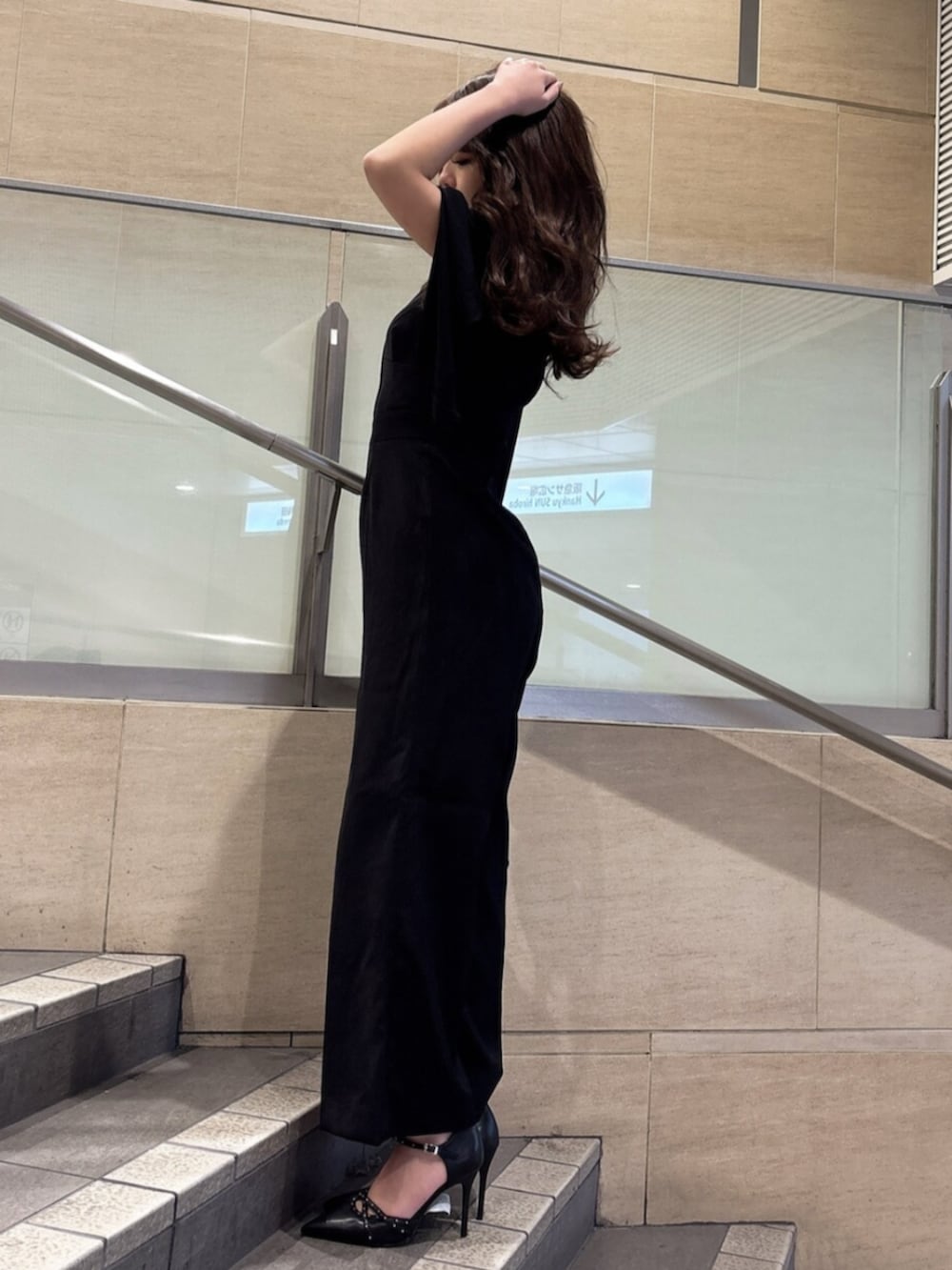 ブラック系のワンピース、ブラック系のハンドバッグ、ブラック系のパンプスを着用したレディースの冬コーディネートの4枚目の写真