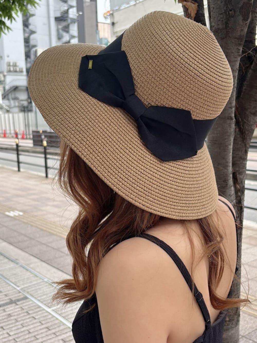 ブラック系のワンピース、ホワイト系のサンダル、ブラウン系のハットを着用したレディースの夏コーディネートの5枚目の写真