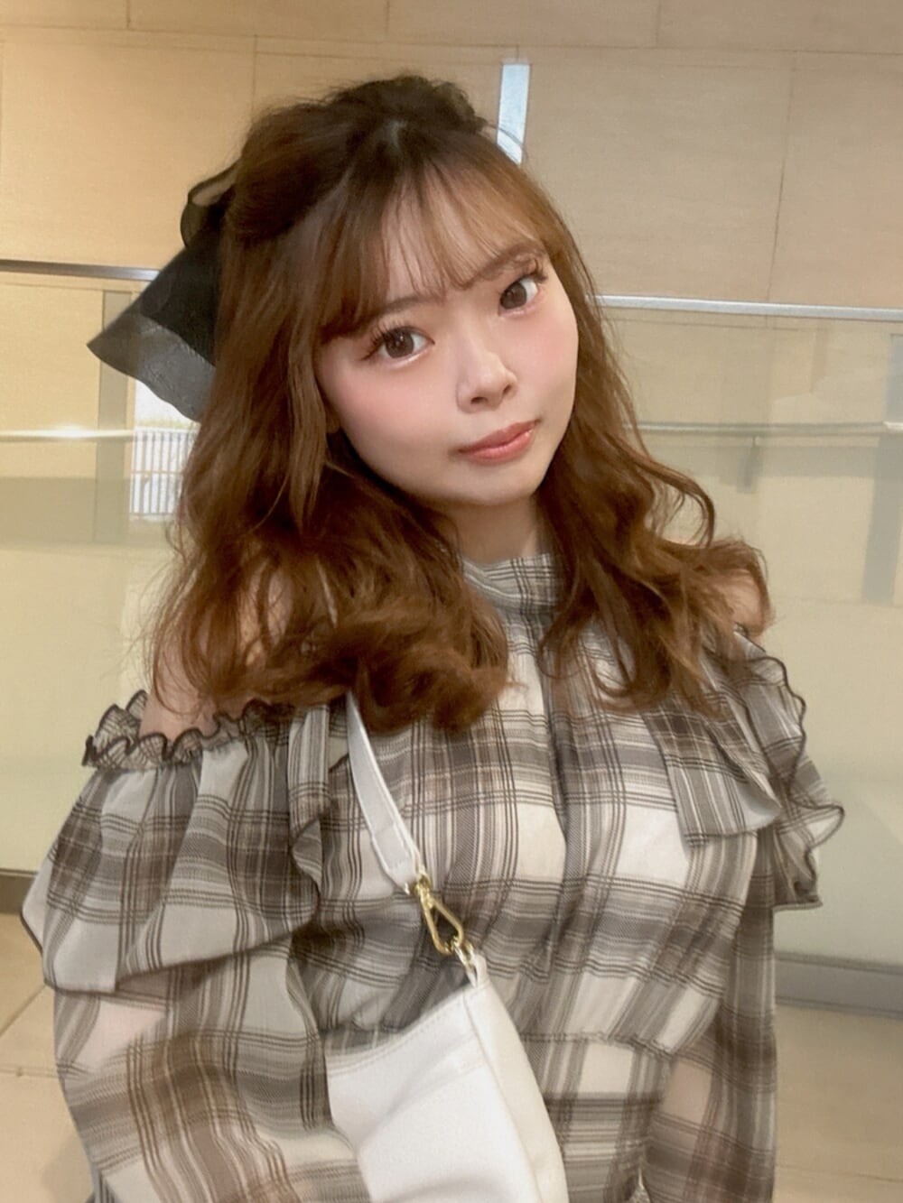 ブラウン系のワンピース、ブラック系のブーツ、ホワイト系のハンドバッグを着用したレディースの春コーディネートの7枚目の写真